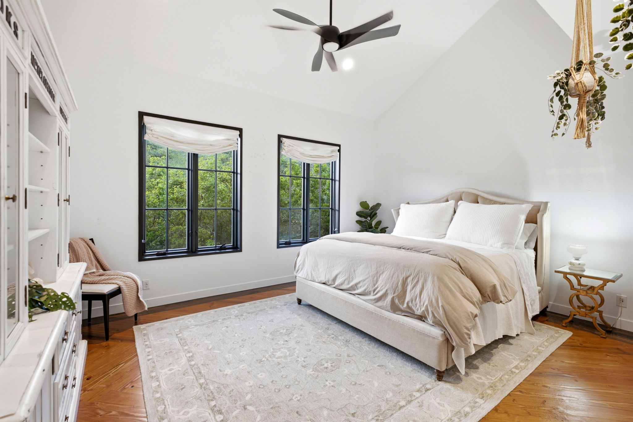 Vaulted ceiling room featuring hardwood flooring and white walls