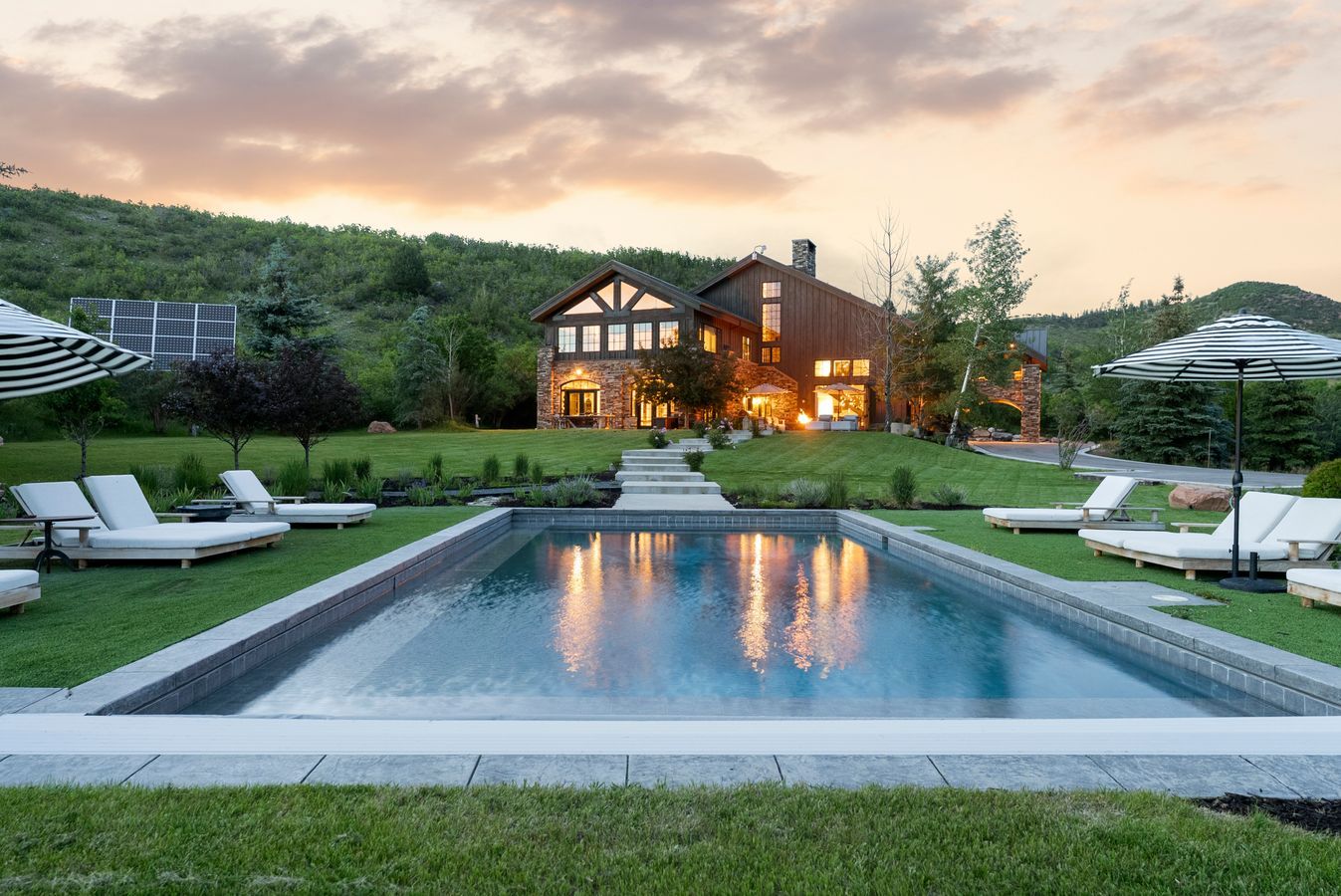 Rectangular swimming pool with stone coping surrounded by manicured lawn