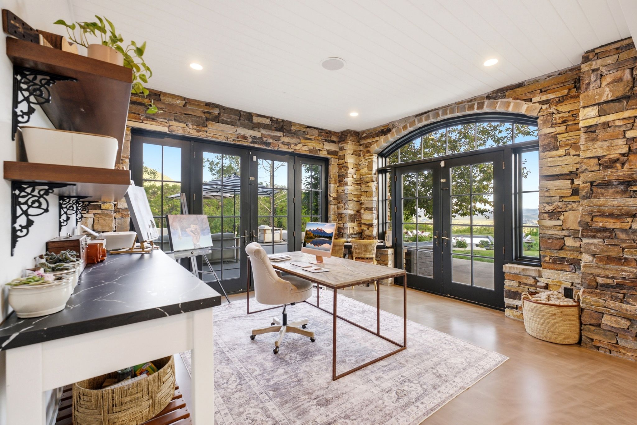 Stone accent walls and a tongue-and-groove ceiling frame this versatile room