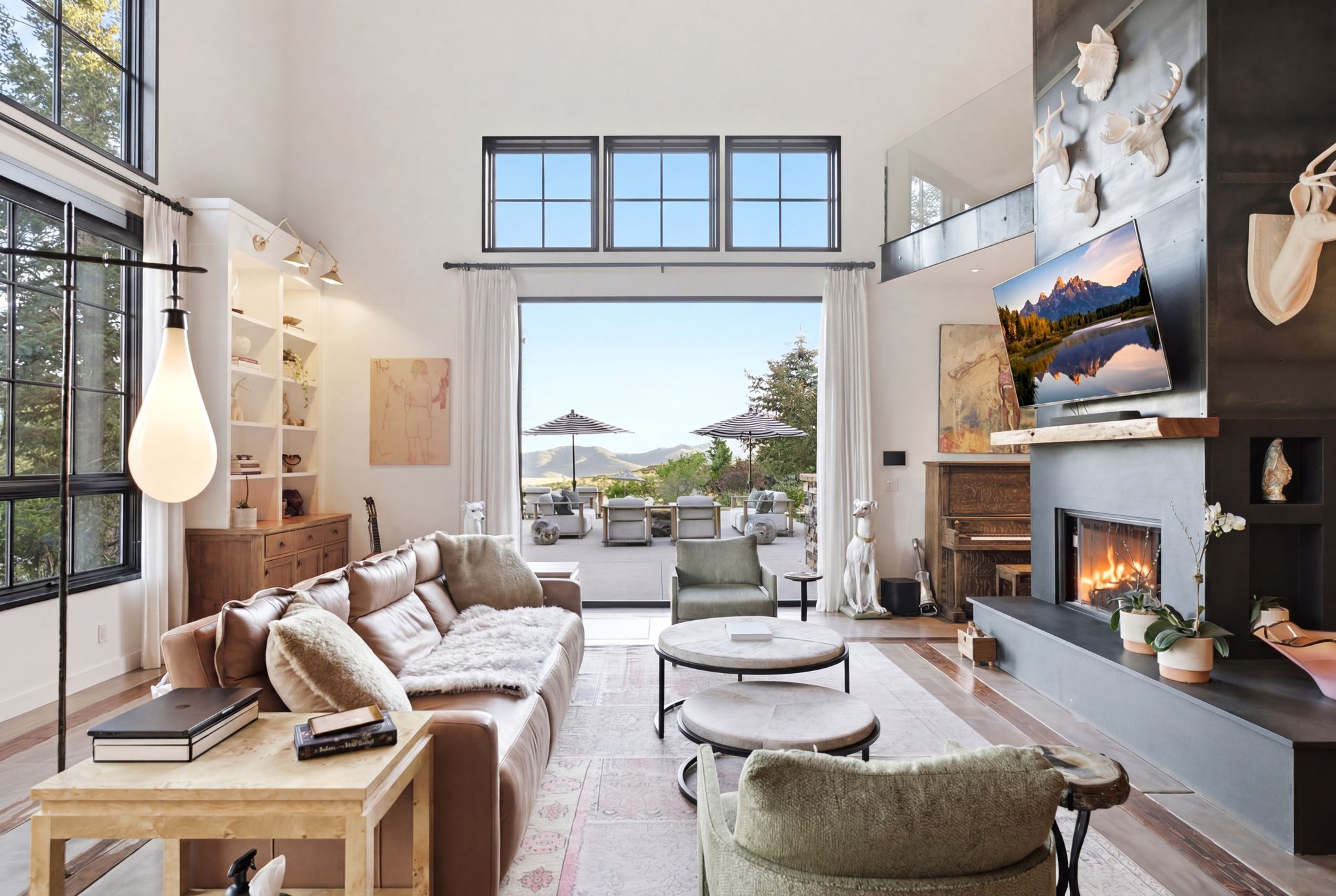Spacious living area featuring high ceilings and expansive glass doors opening to an outdoor patio
