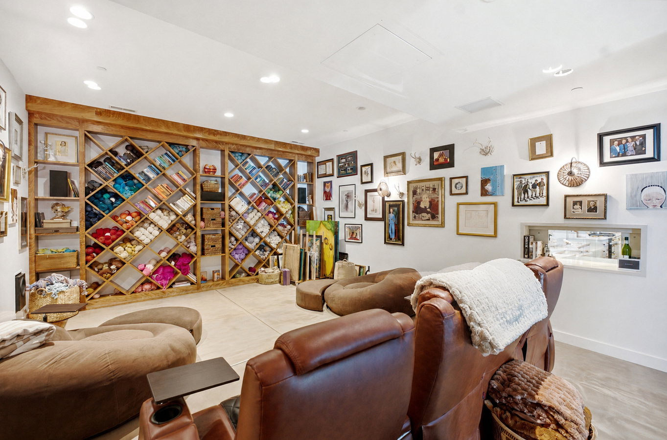 Spacious room featuring a custom built-in wooden shelving unit, recessed lighting, and light-toned flooring