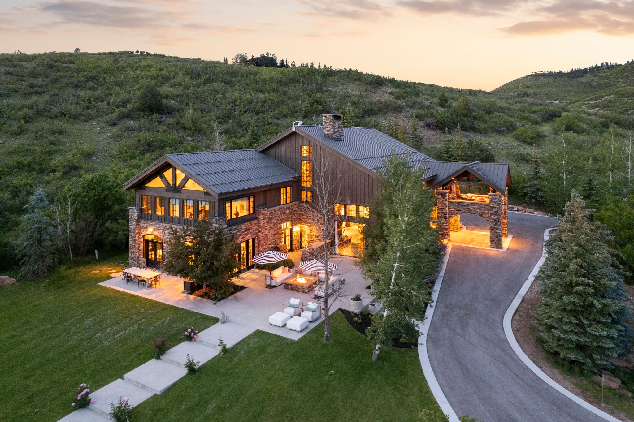 Stone and wood-sided architectural residence featuring a prominent porte-cochère