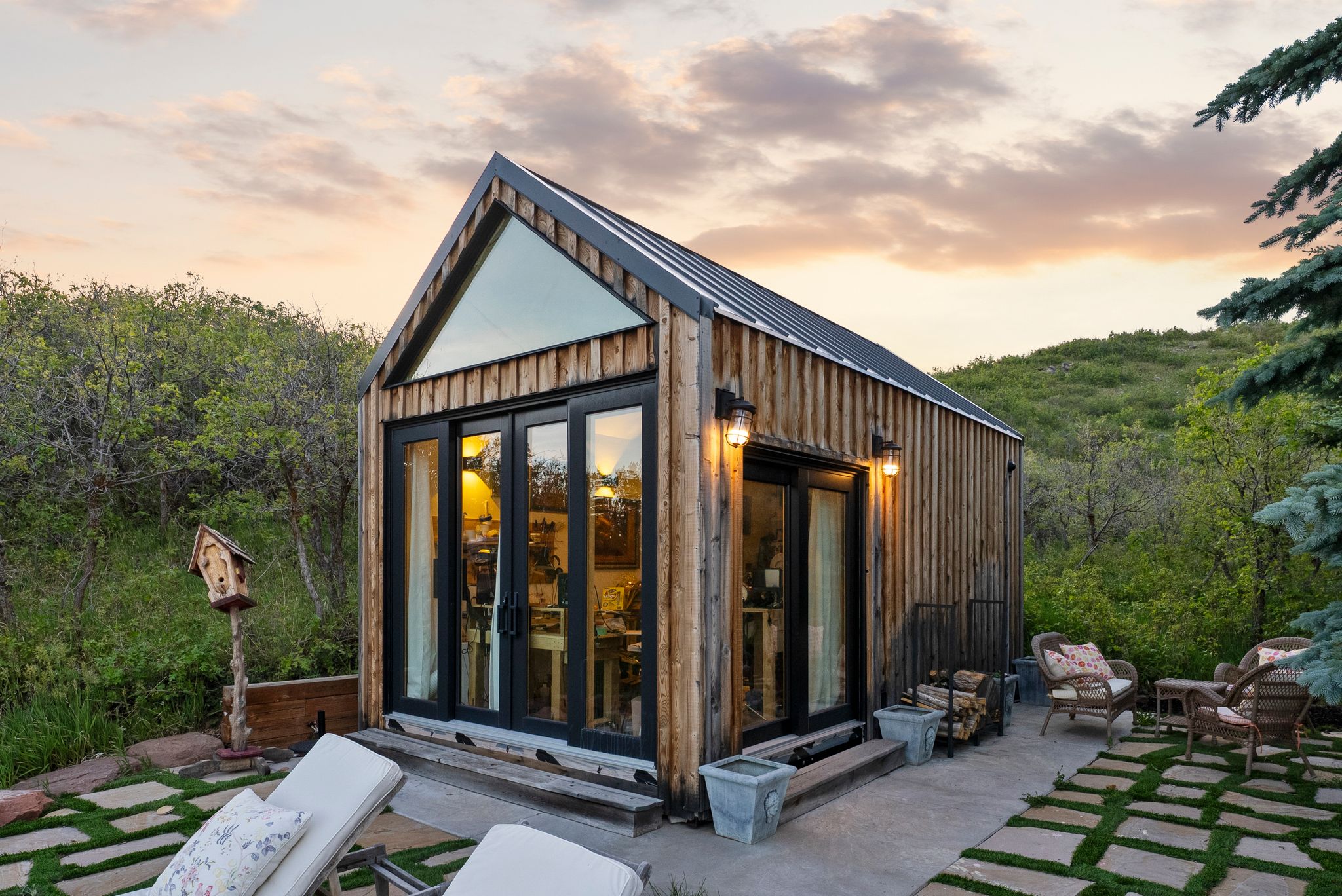 Modern cabin structure with natural wood siding and a black metal roof