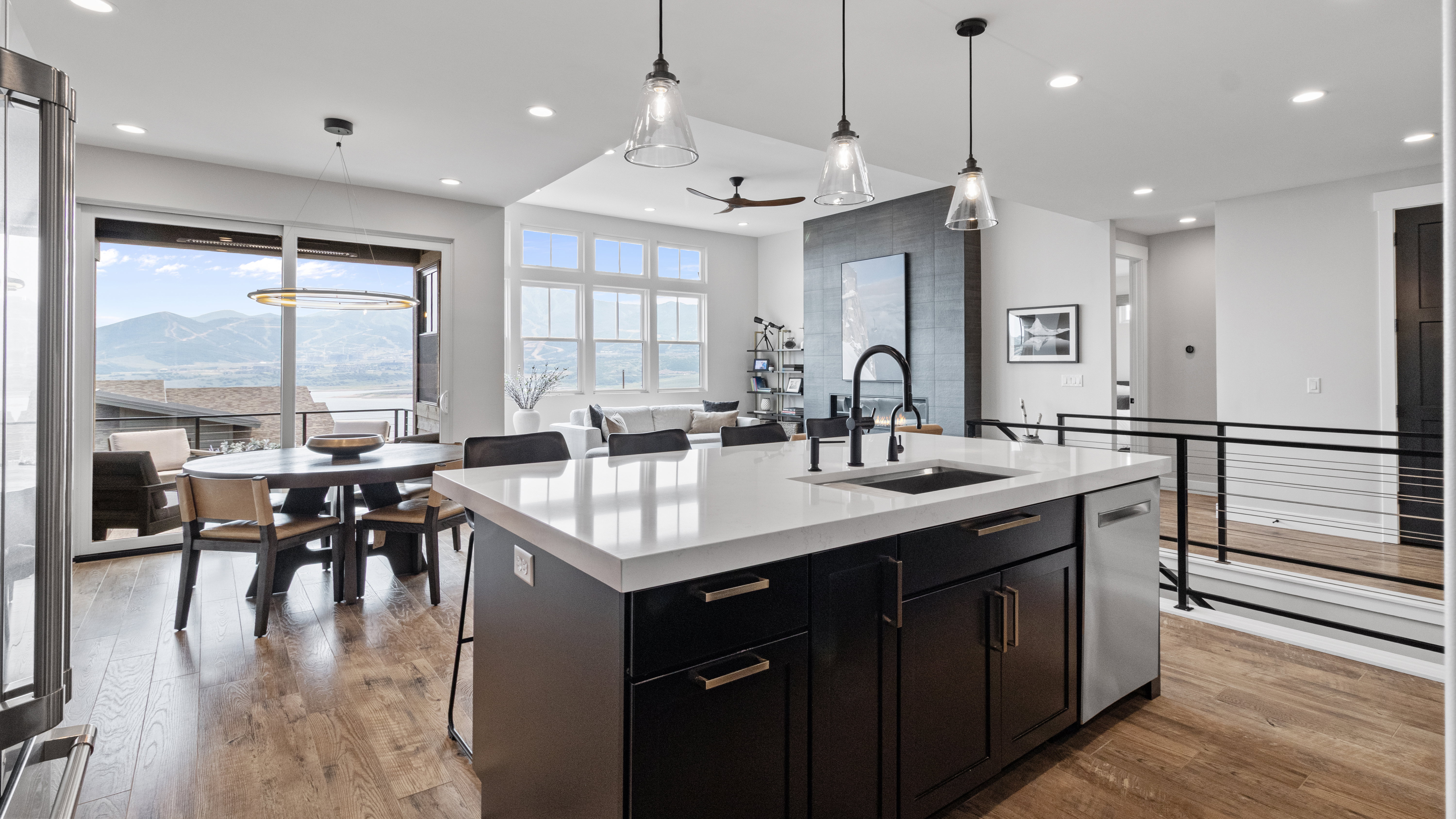 Kitchen island featuring a white countertop, undermount sink, and black cabinetry