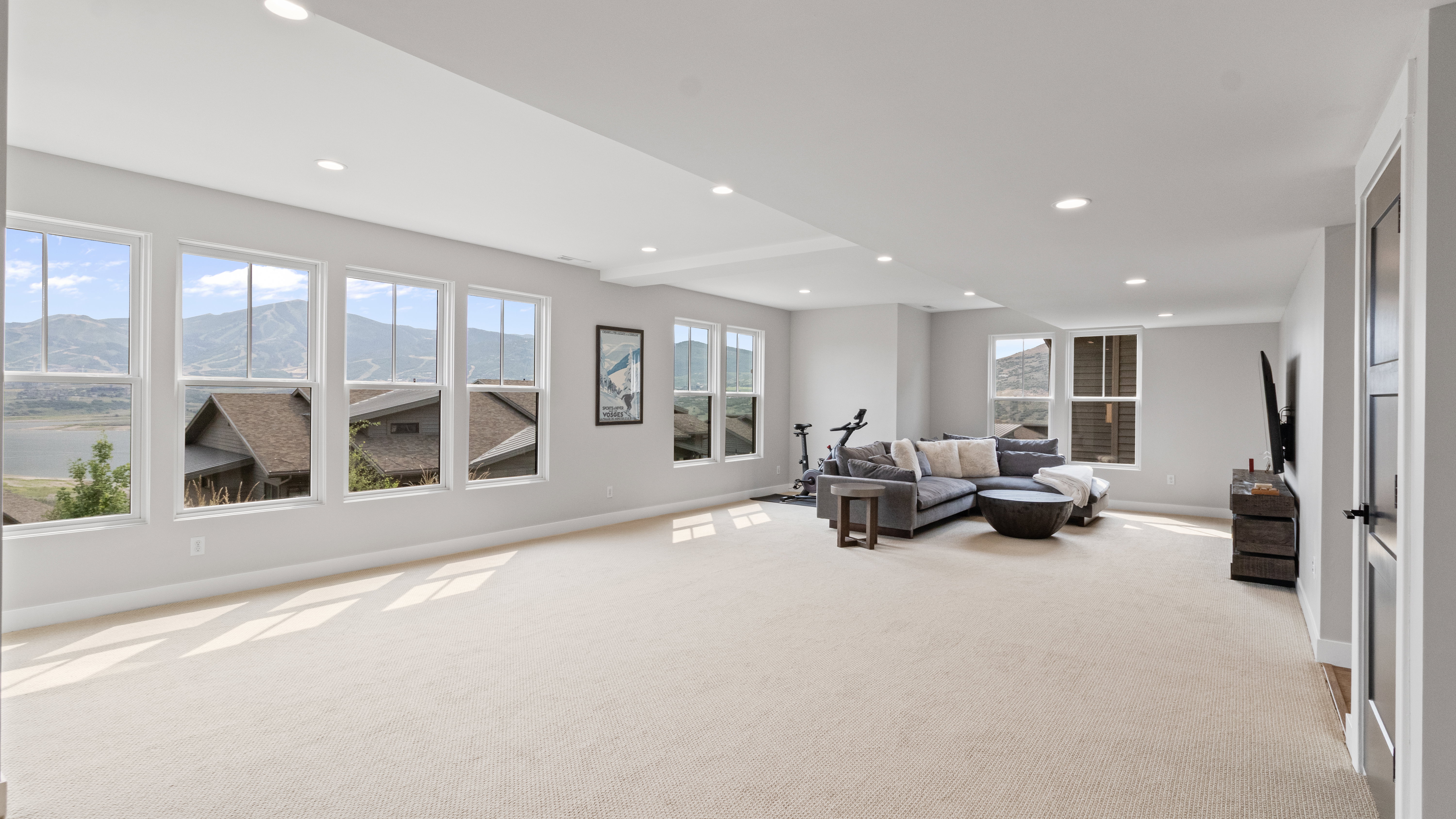 Spacious room with light-toned carpeting and recessed lighting