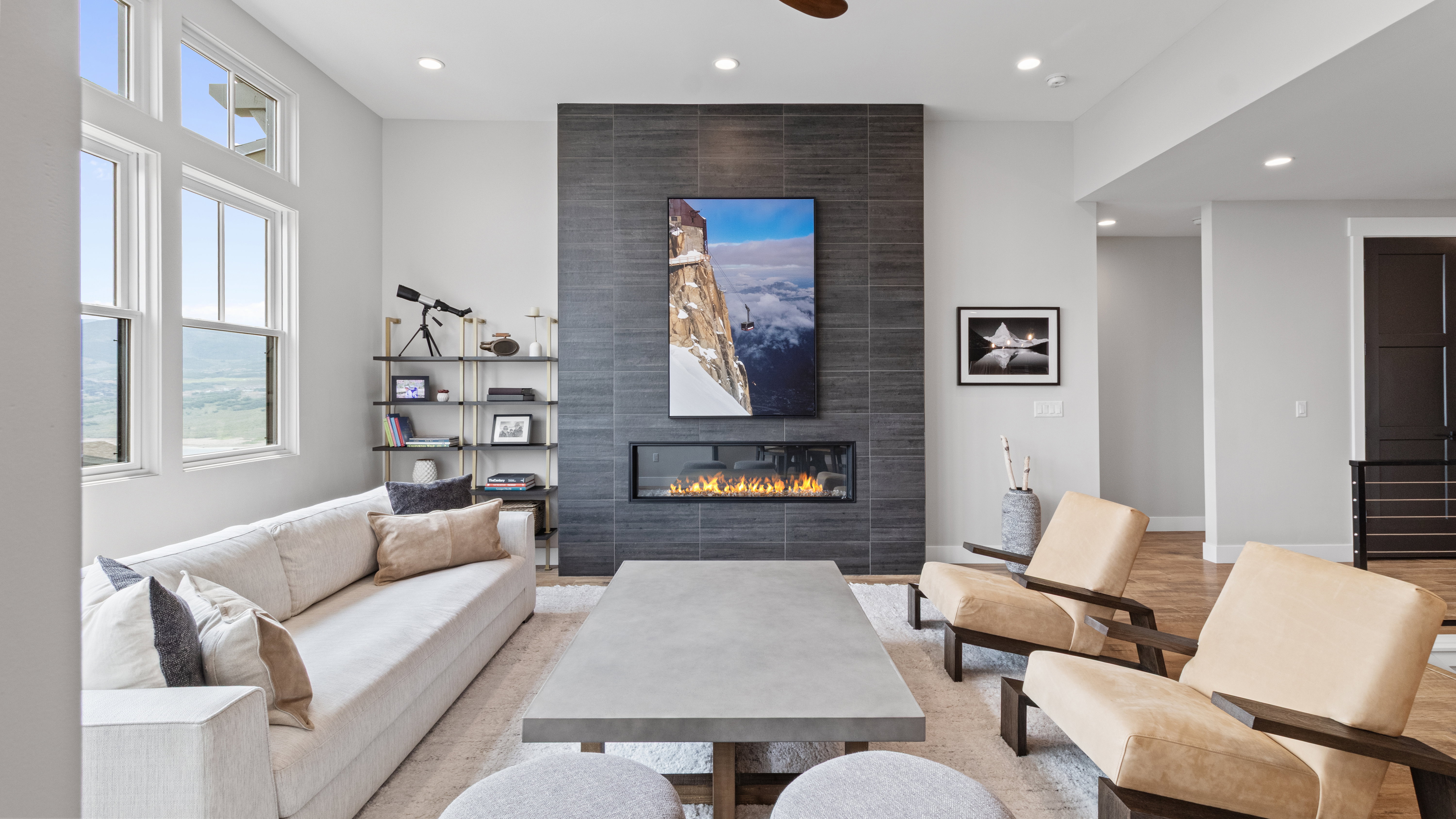 Living area featuring a floor-to-ceiling tiled fireplace, linear electric fireplace insert, and high transom windows