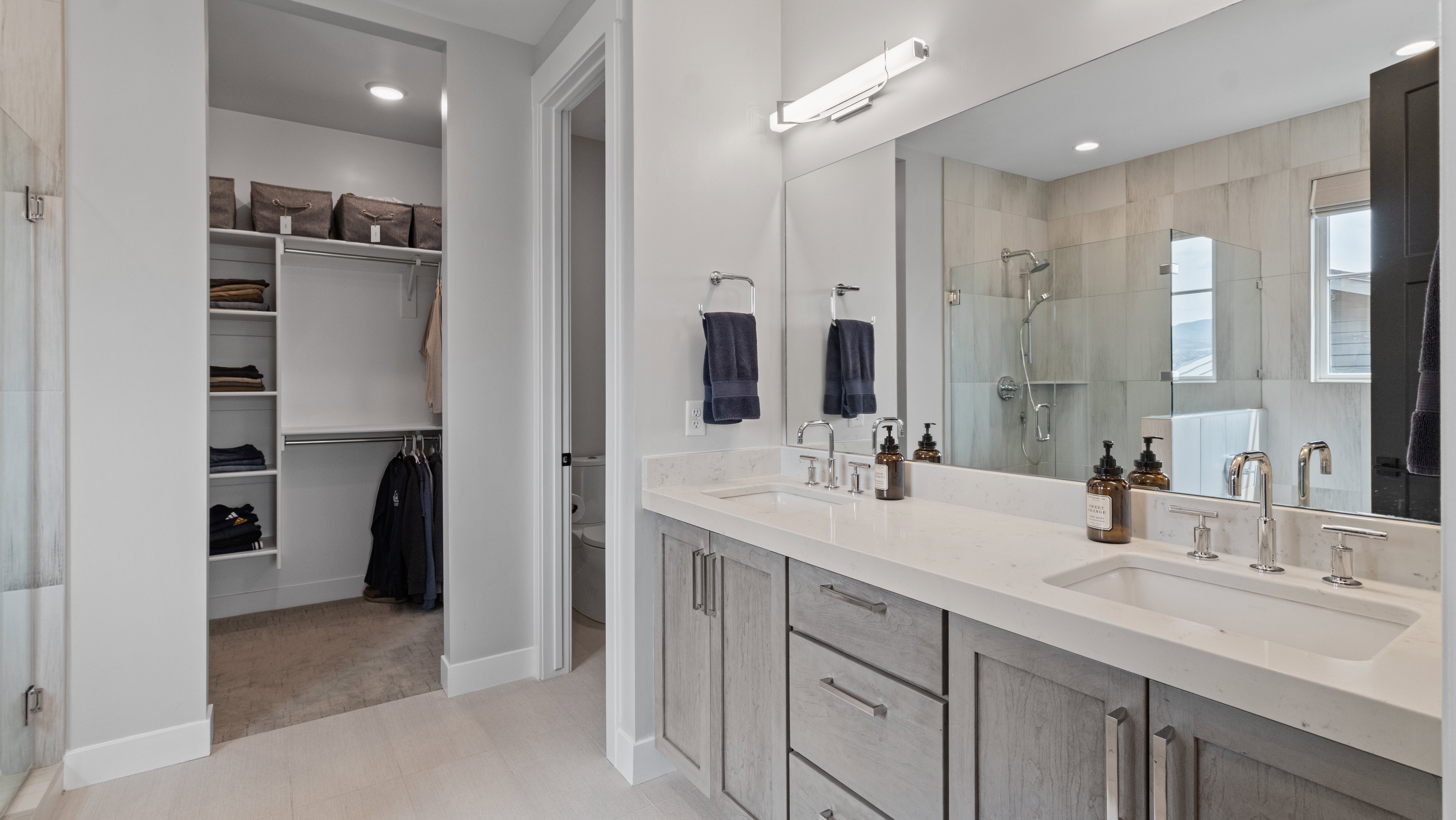 Primary suite's double vanity with integrated sinks and chrome fixtures
