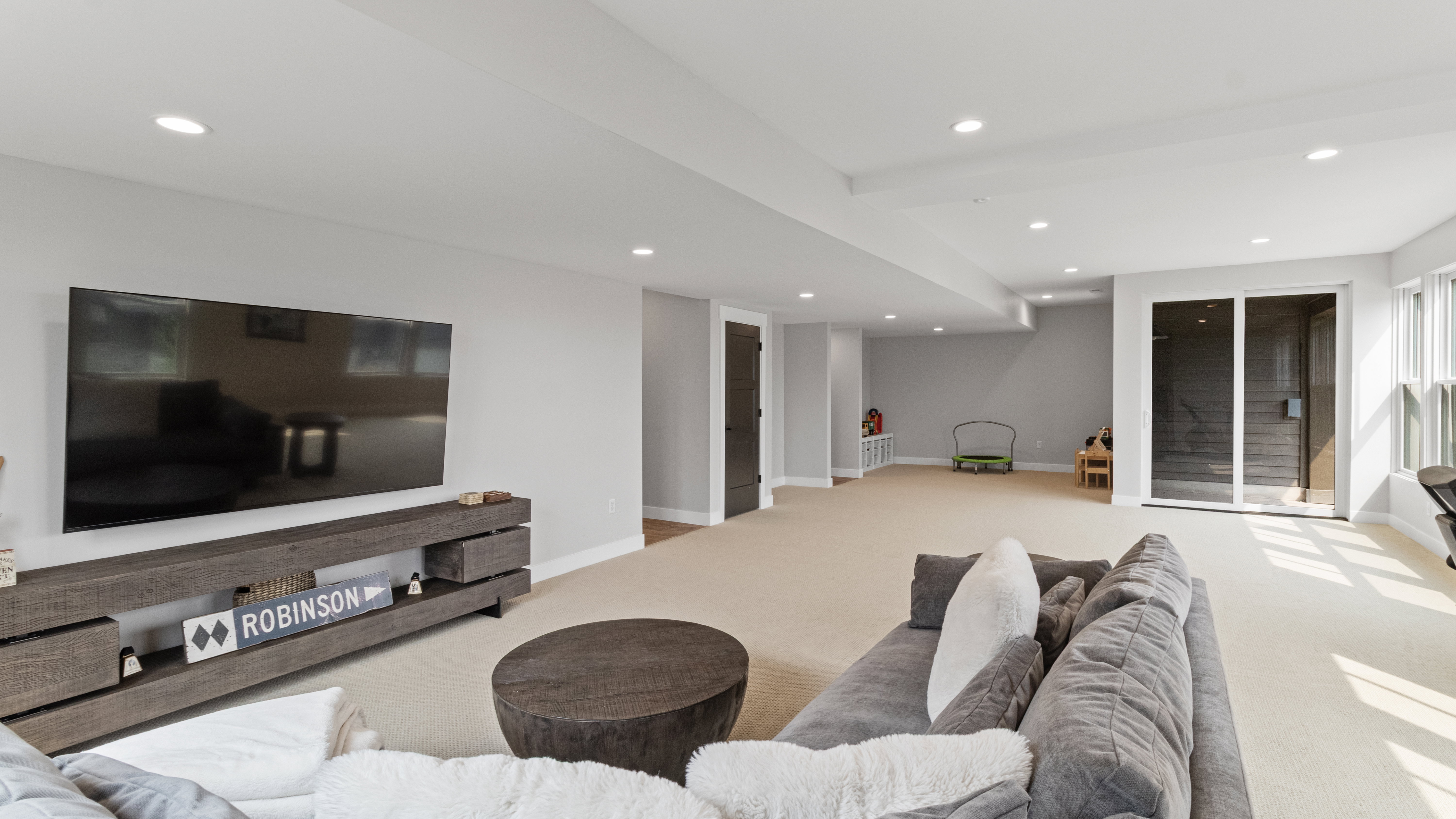 Spacious lower-level room featuring recessed lighting, light-toned carpeting, and light gray walls