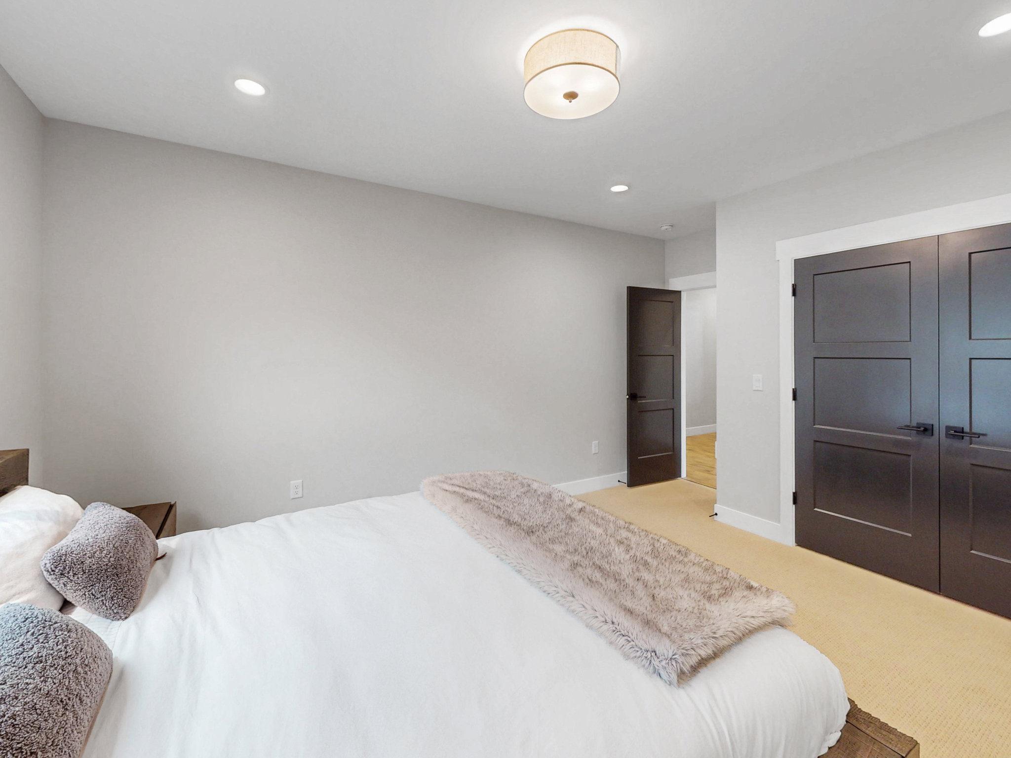 Bedroom #3 features neutral wall tones, recessed lighting, a central flush-mount light fixture, dark panel doors with matte black hardware, and carpet flooring