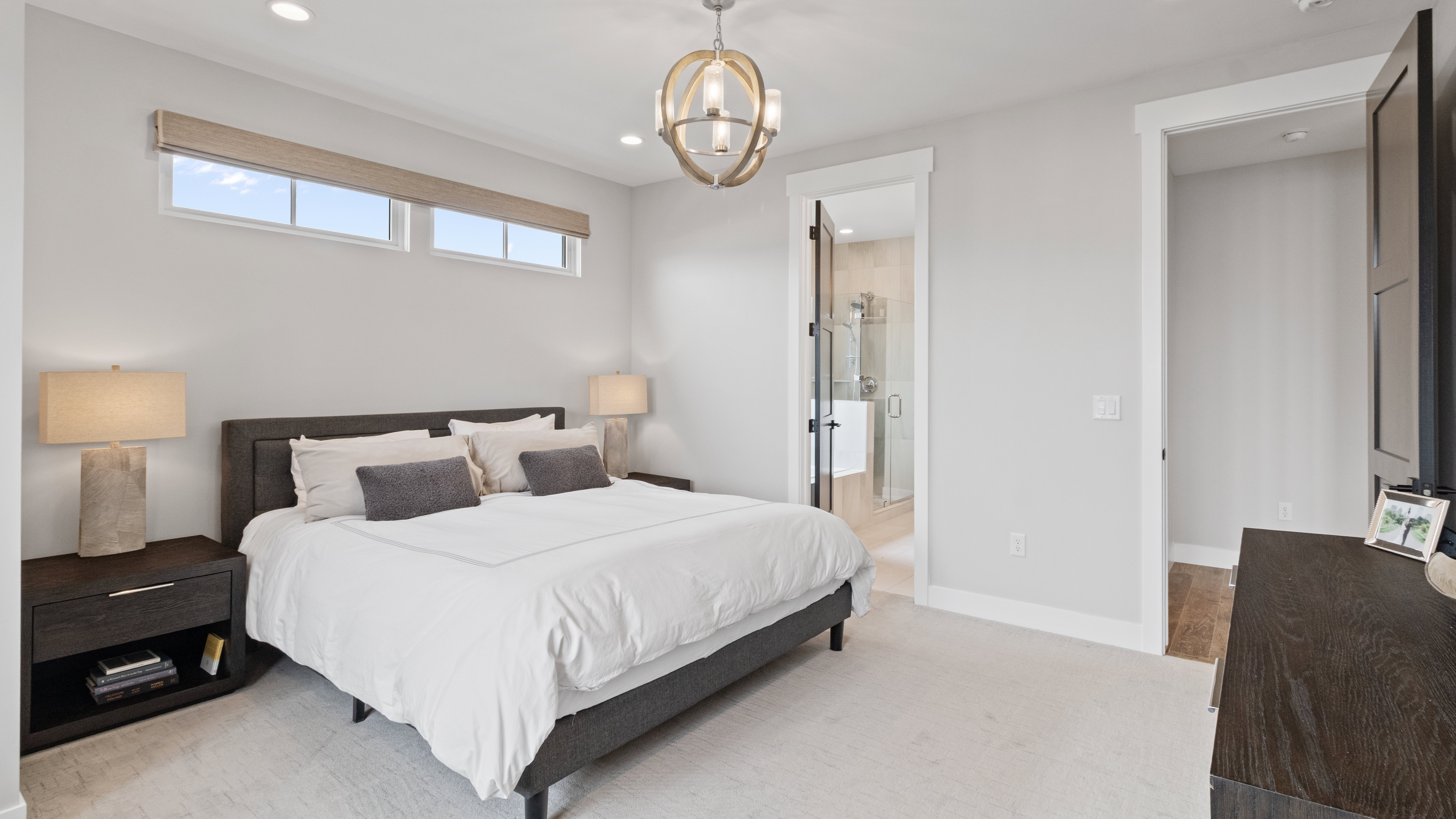 Spacious Primary suite featuring light-colored carpeting, recessed lighting, and a contemporary spherical chandelier