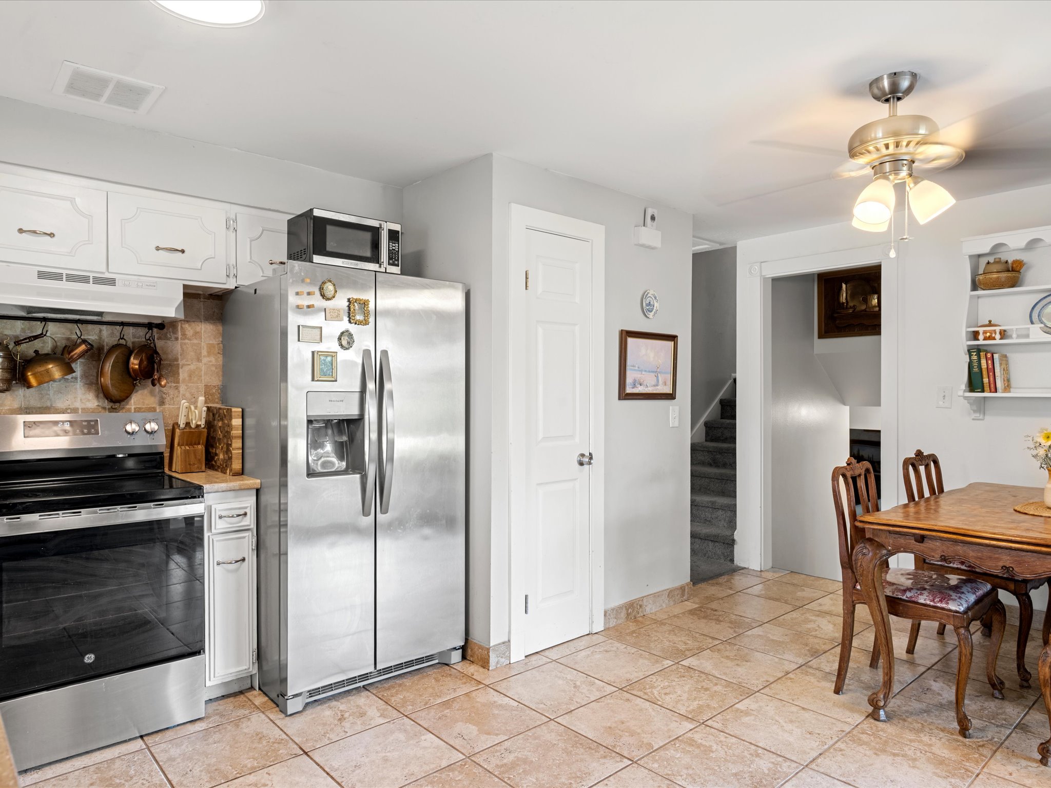 Kitchen featuring white cabinetry, stainless steel appliances, and tiled flooring