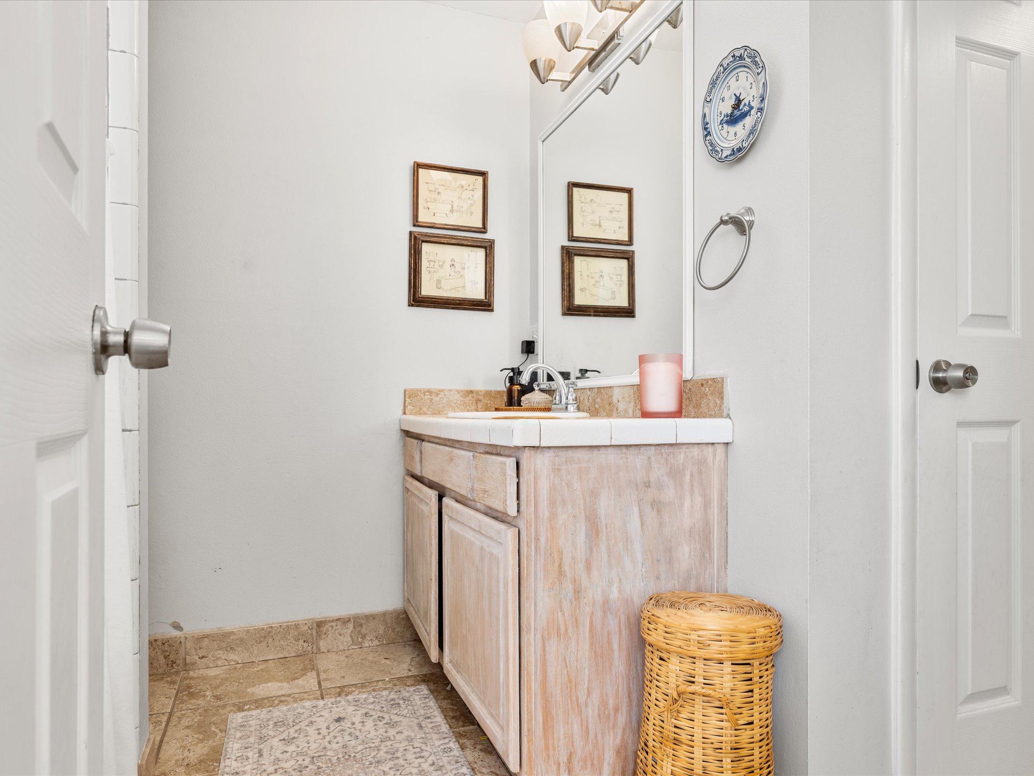 Bathroom vanity featuring a tile countertop, integrated sink, and brushed nickel faucet