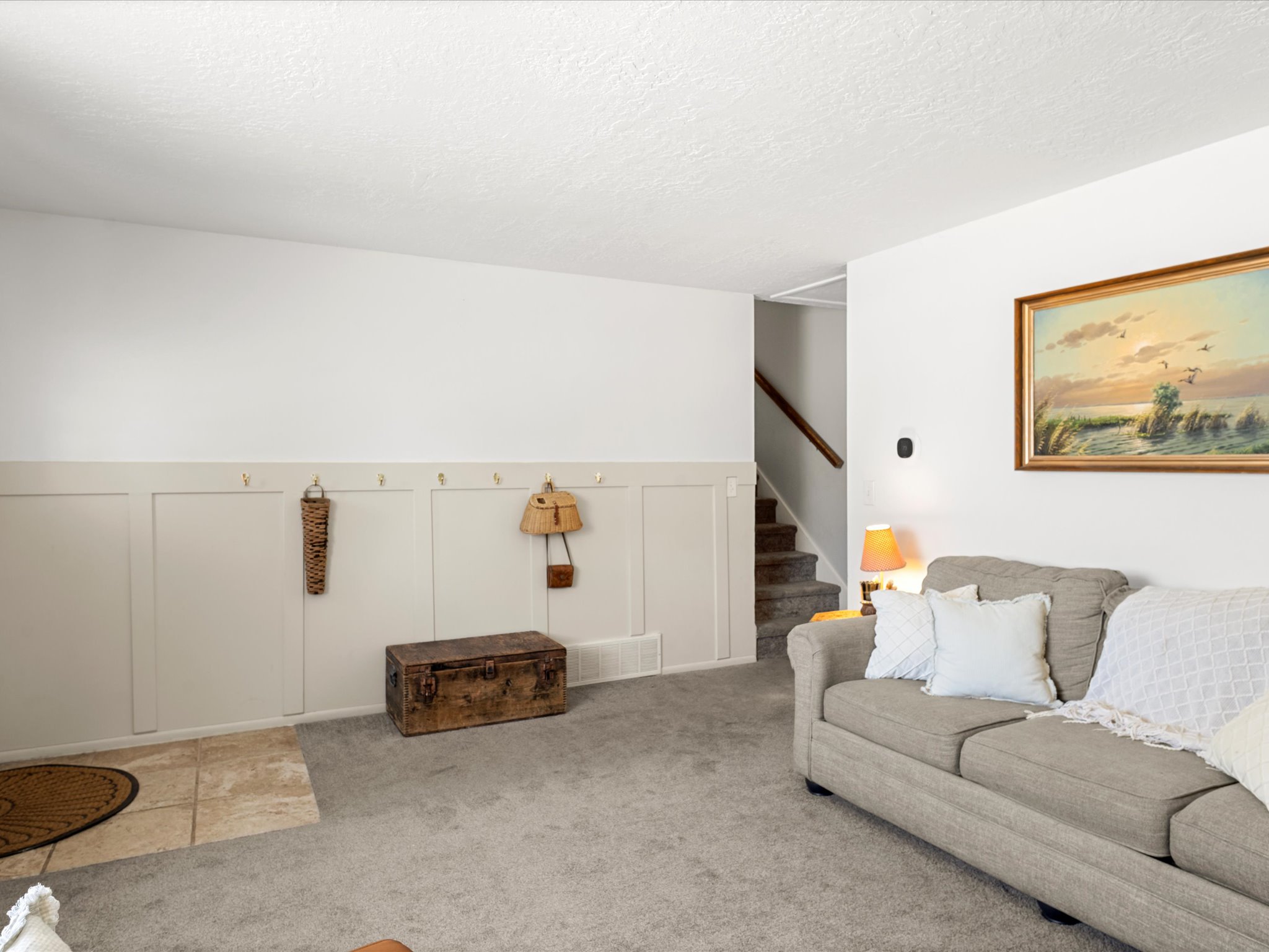 Light-colored carpeting throughout the main area, complemented by wainscoting with coat hooks along one wall