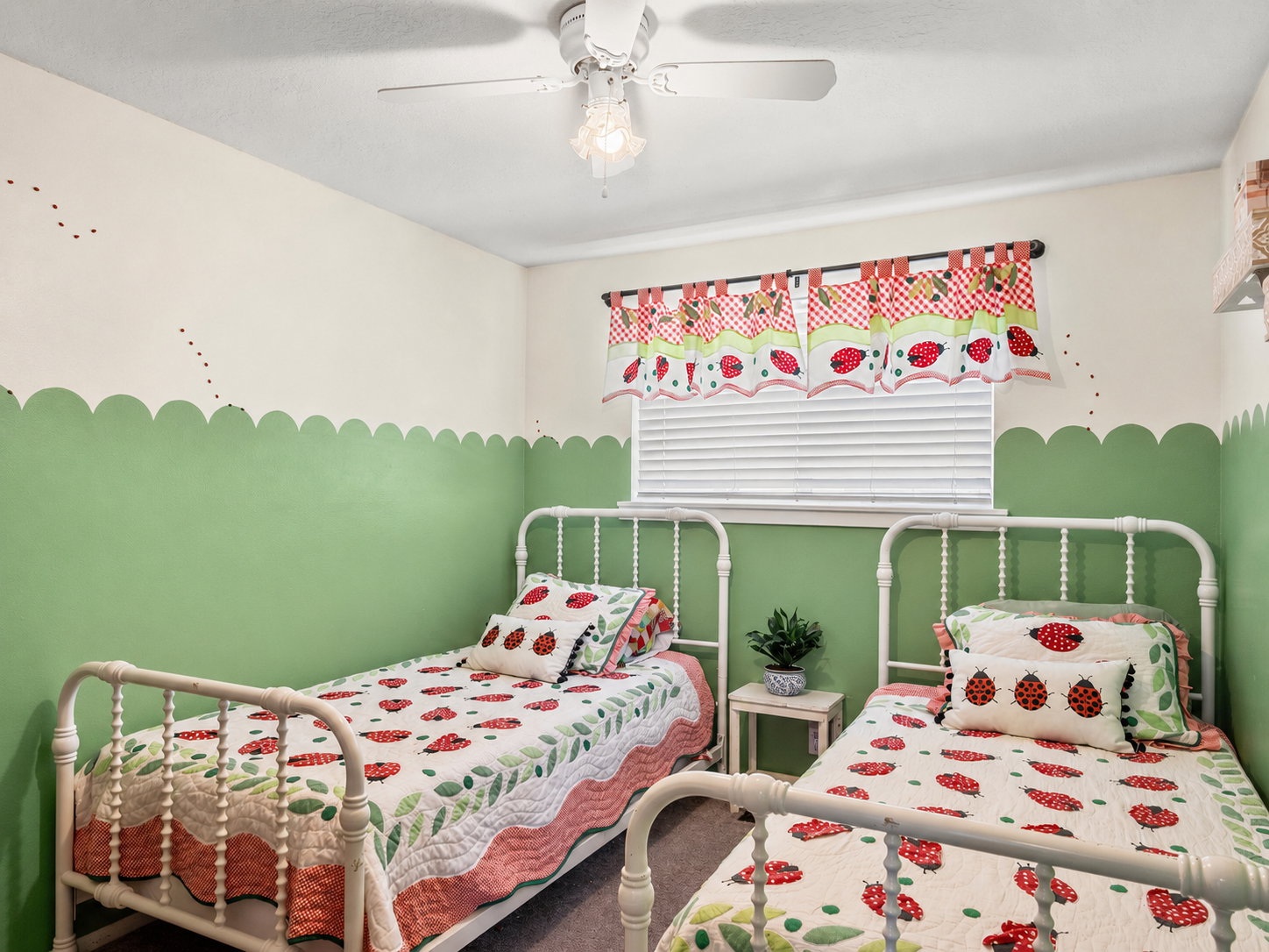 Room featuring a window with horizontal blinds, a ceiling fan with light fixture, and two-tone painted walls with a scalloped border