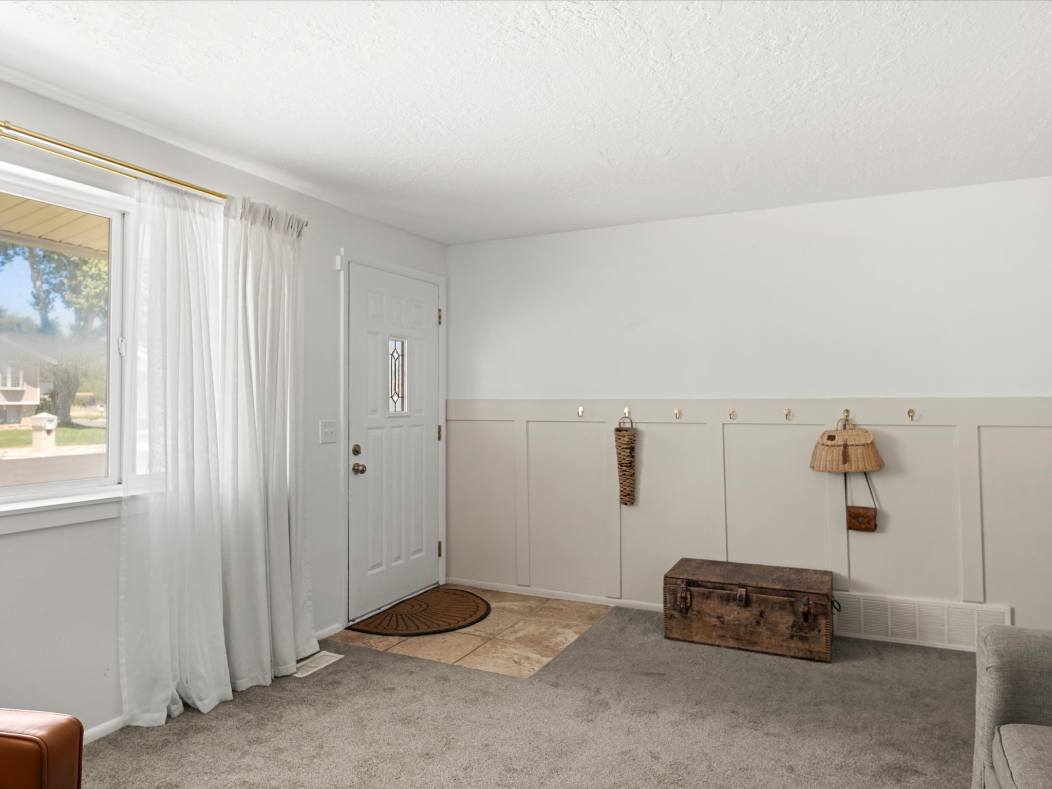 Entryway featuring a paneled accent wall with integrated hooks