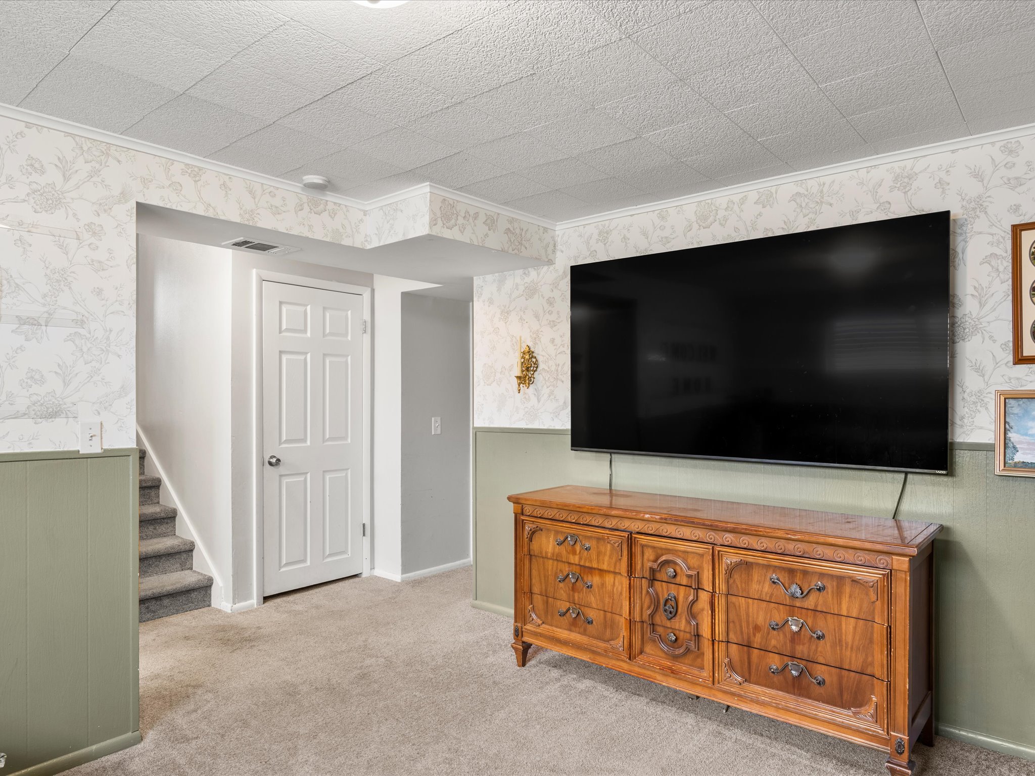 Carpeted room down from the kitchen
