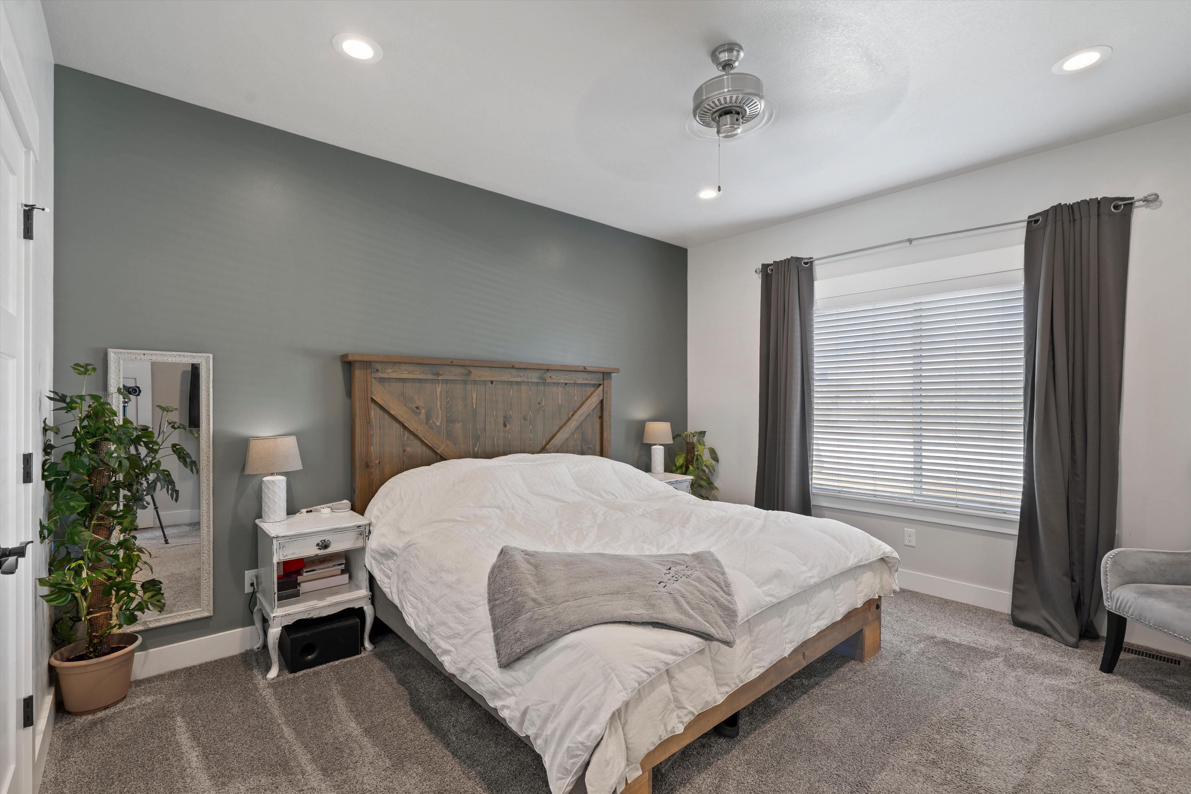 Carpeted bedroom featuring a wood headboard, recessed lighting, and a ceiling fan