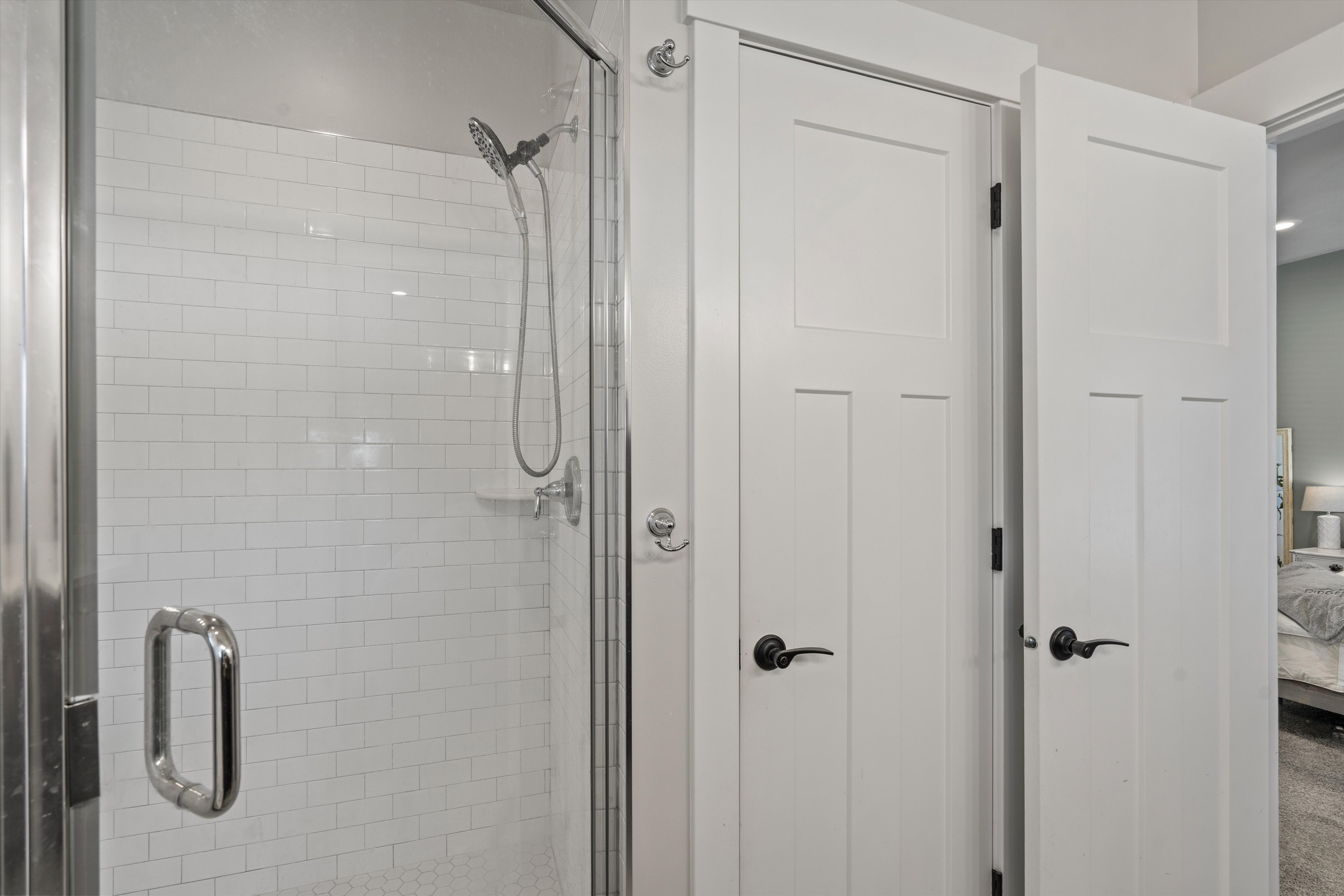 Glass-enclosed shower with subway tile surround, chrome fixtures, and a multi-function showerhead