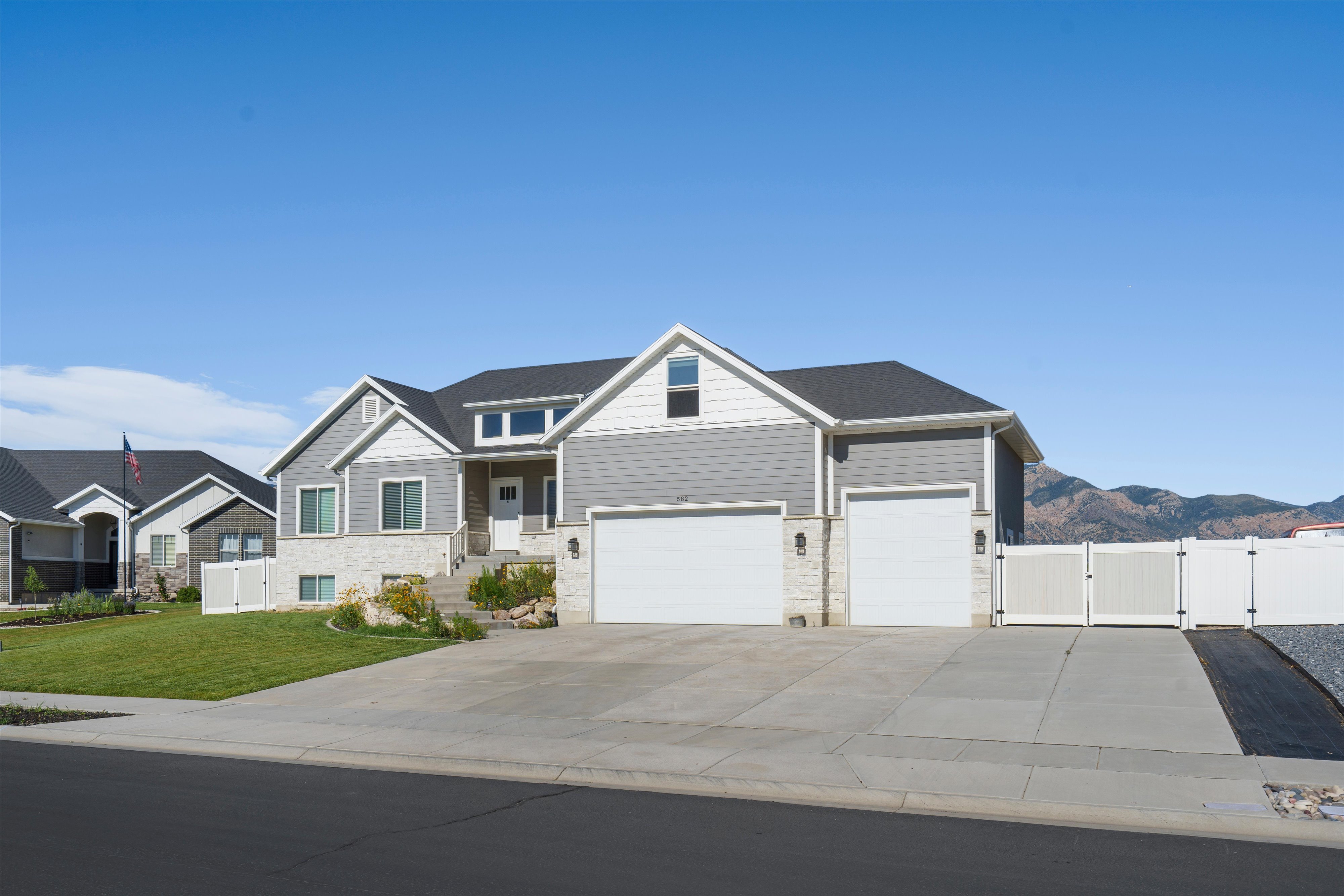 Contemporary two-story residence with gray siding and stone accents
