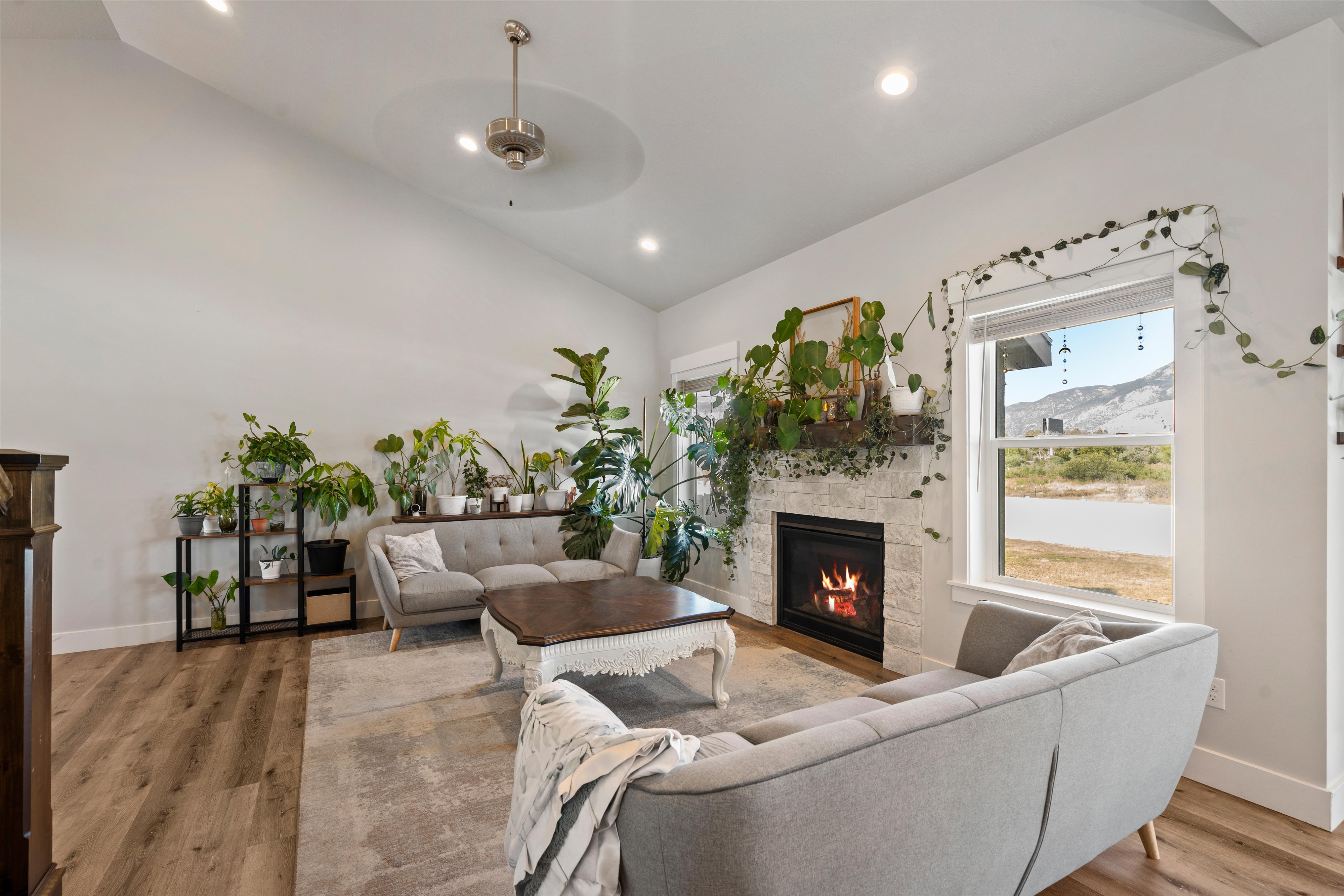 Living area featuring vaulted ceilings, recessed lighting, and wood-finish flooring