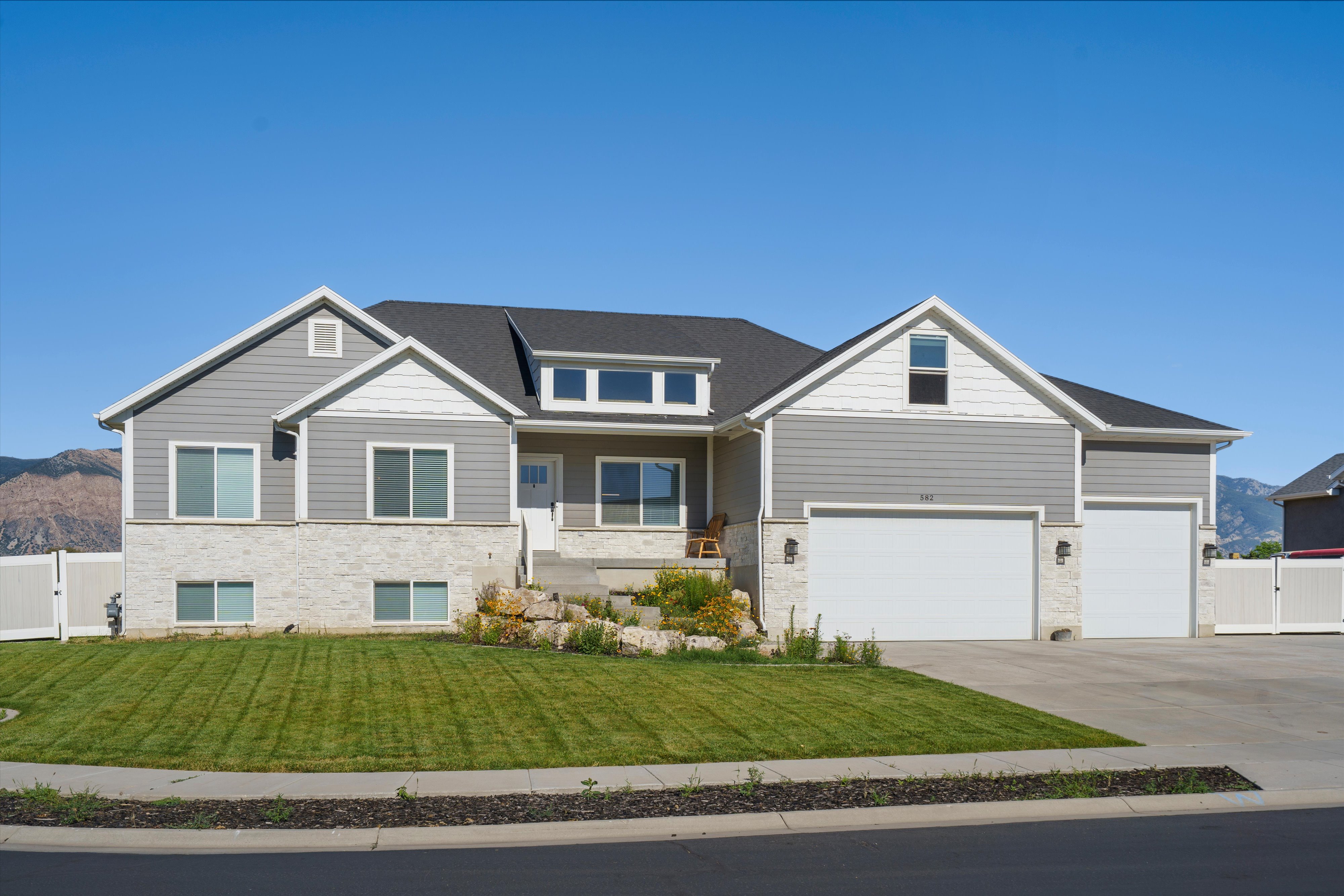 Contemporary residence featuring gray siding and white stone accents