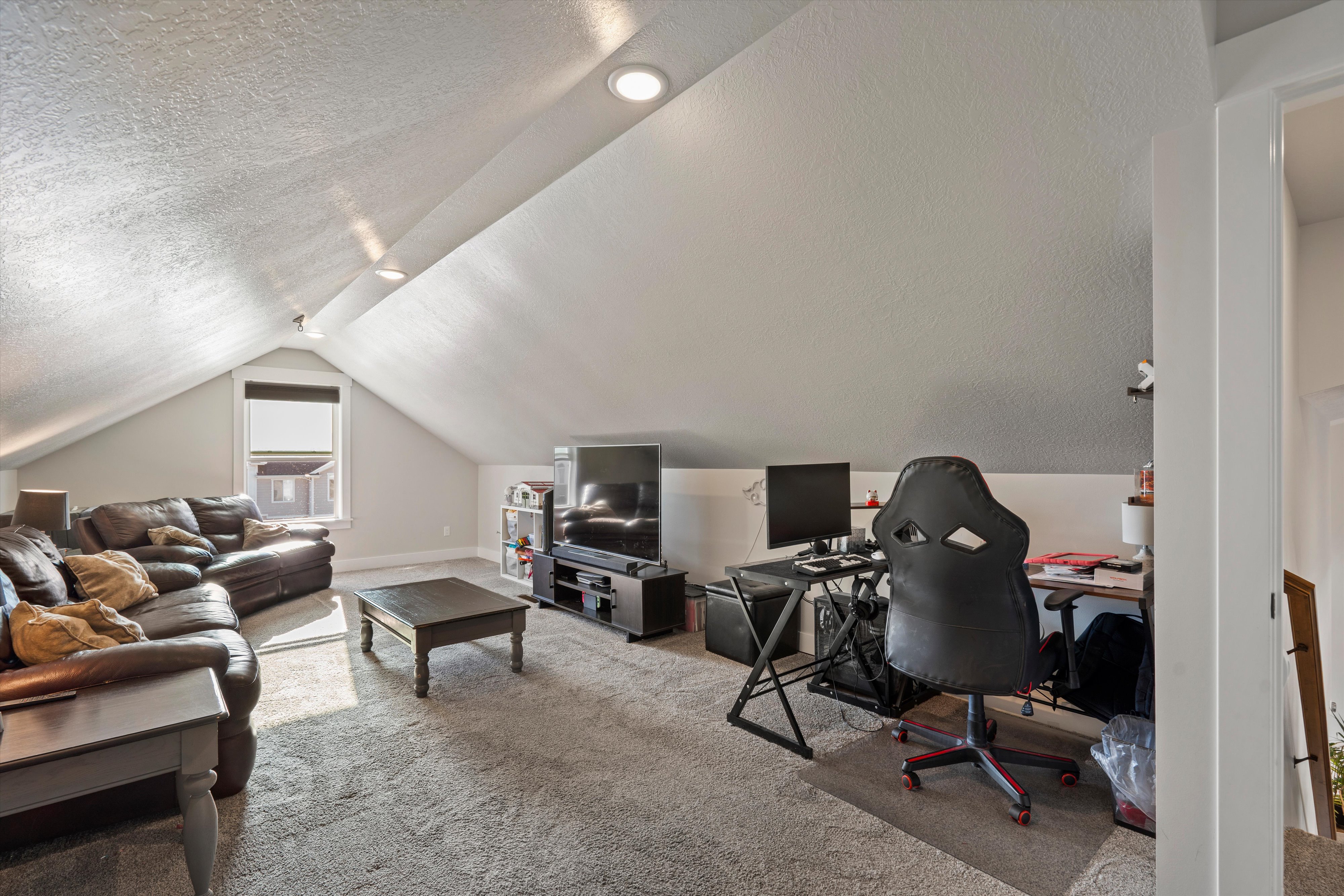 Expansive bonus room featuring sloped ceilings, recessed lighting, and a neutral carpeted floor