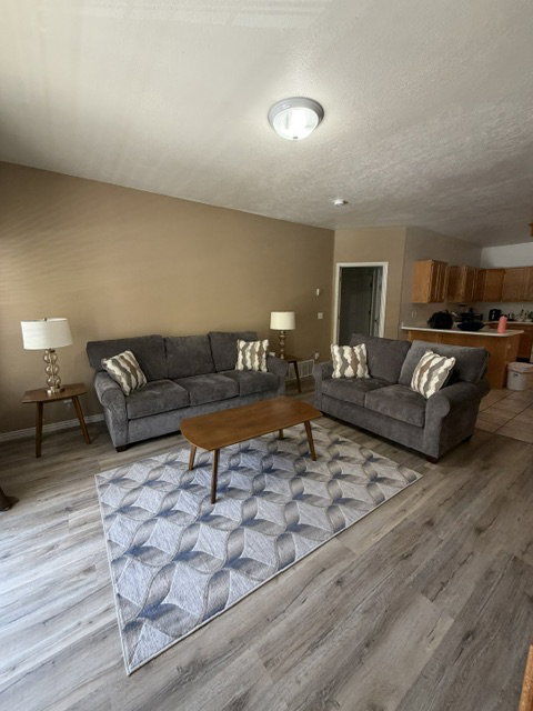 Open-concept living area featuring wood-finish flooring and a neutral color palette