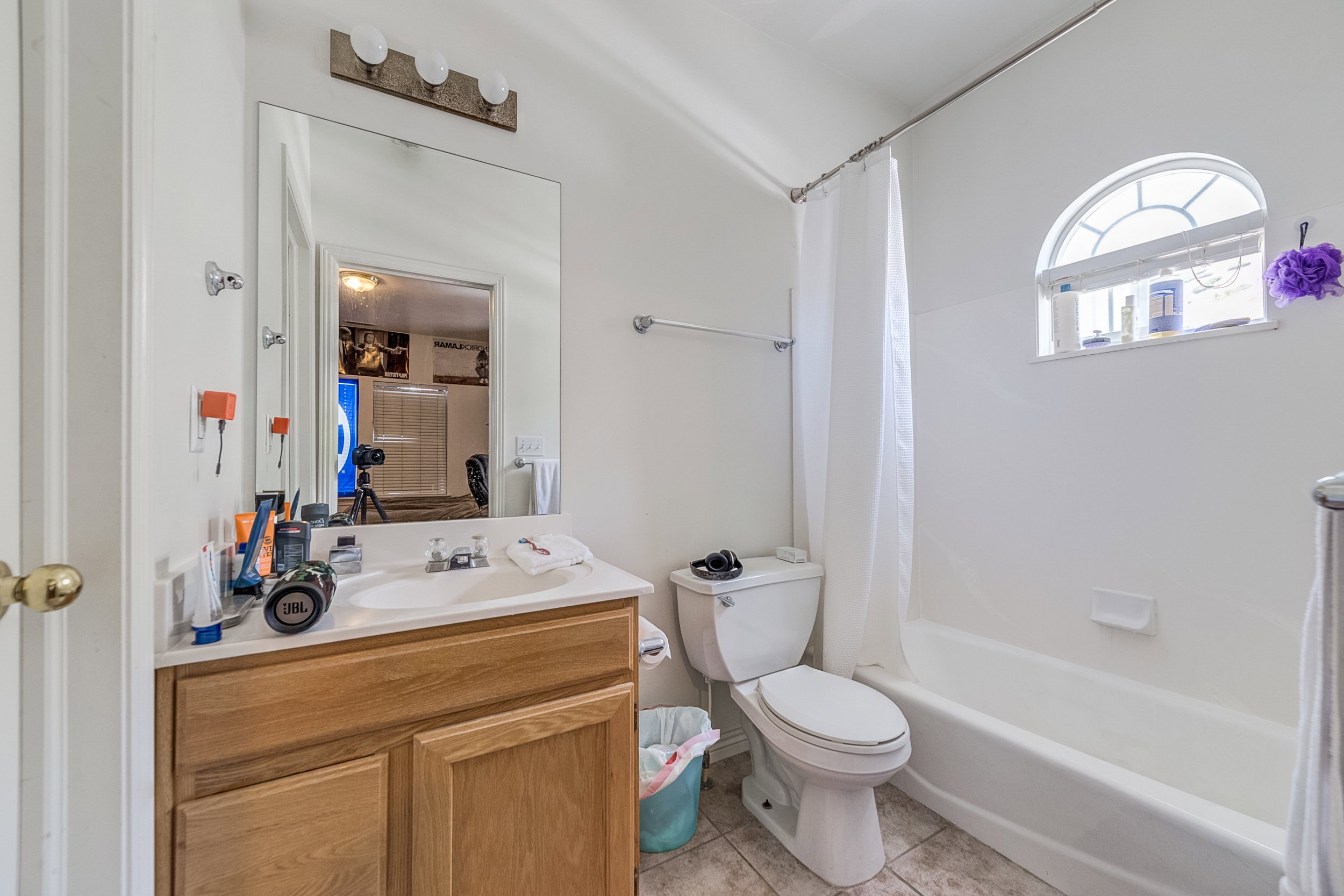Bathroom featuring a wood-finish vanity with a white countertop and integrated sink