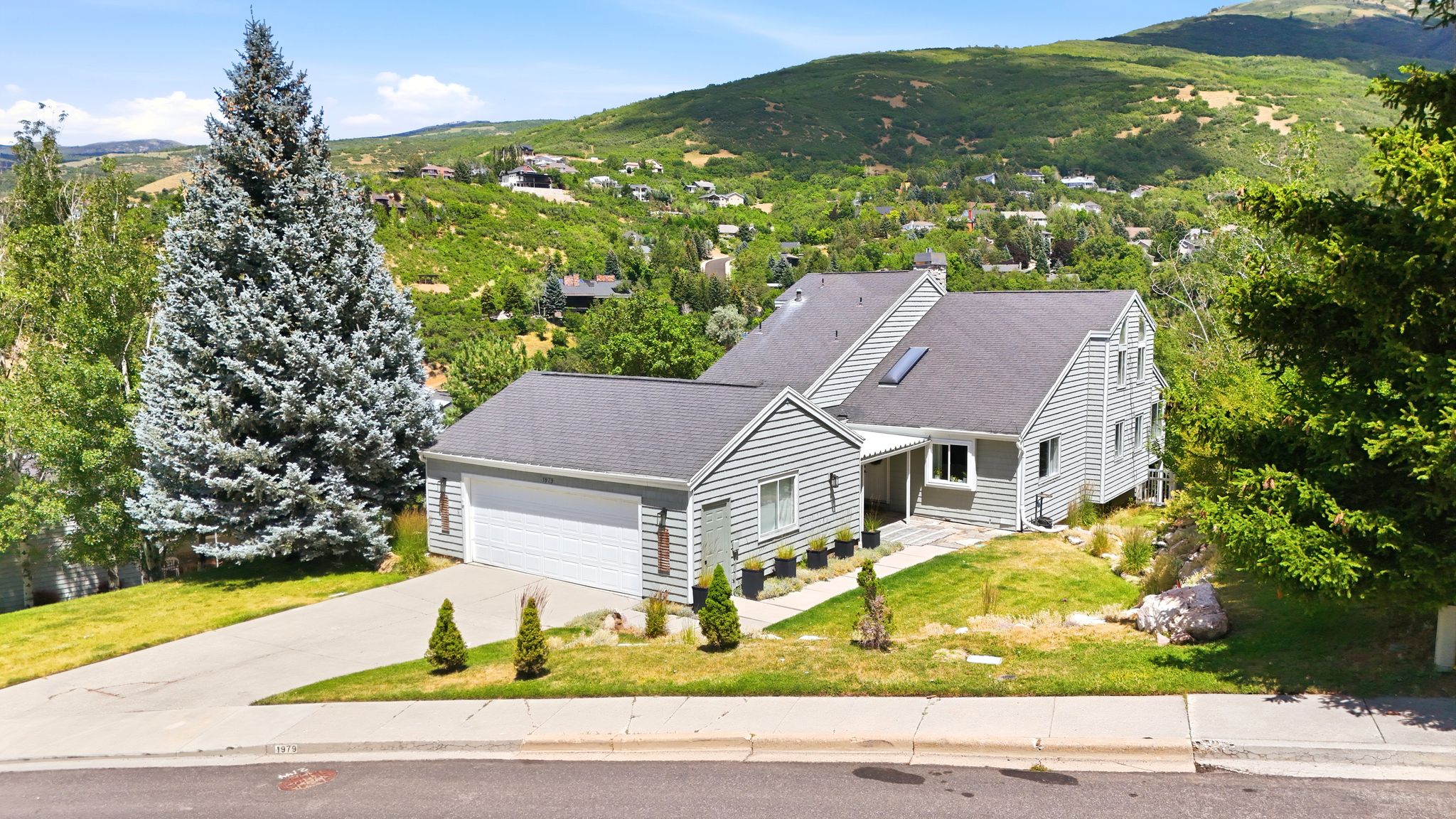 Multi-level residence featuring gray siding and a dark shingle roof