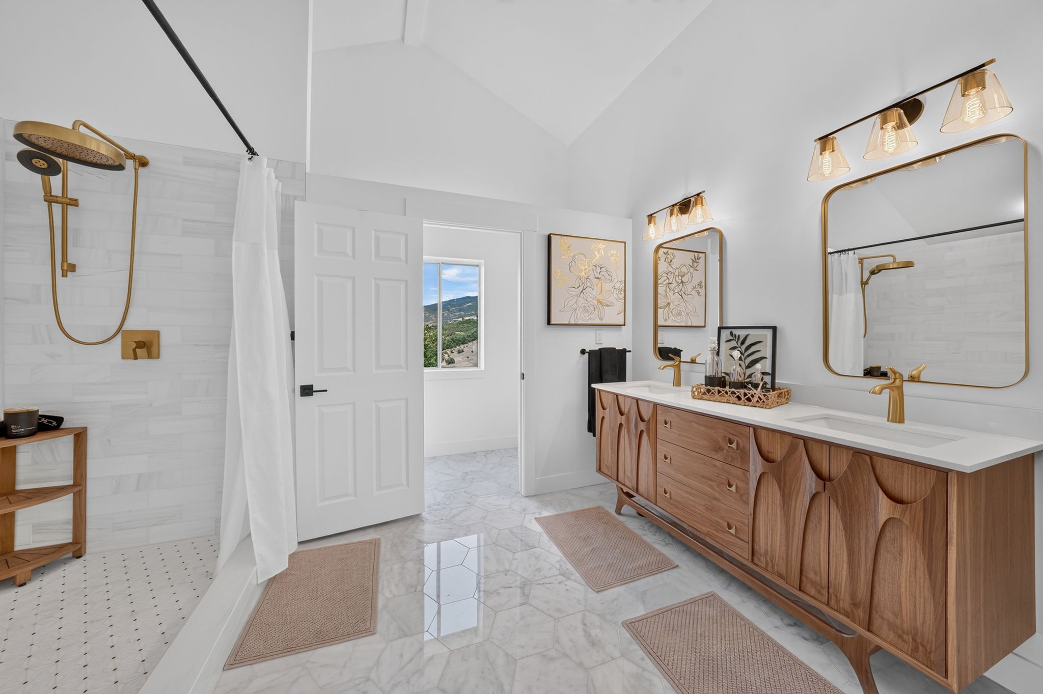 Spacious bathroom featuring a double vanity with ample storage, a large walk-in shower with a gold-tone rain showerhead, and hexagon-patterned tile flooring