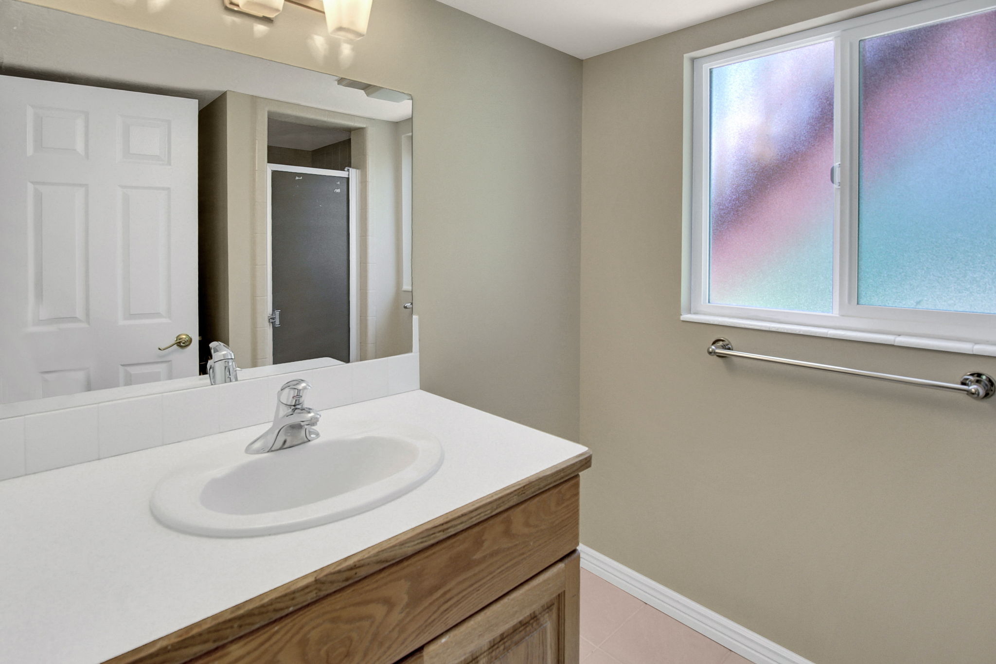 Bathroom #3 featuring a wood-finish vanity with an integrated sink and a white countertop on first lower level