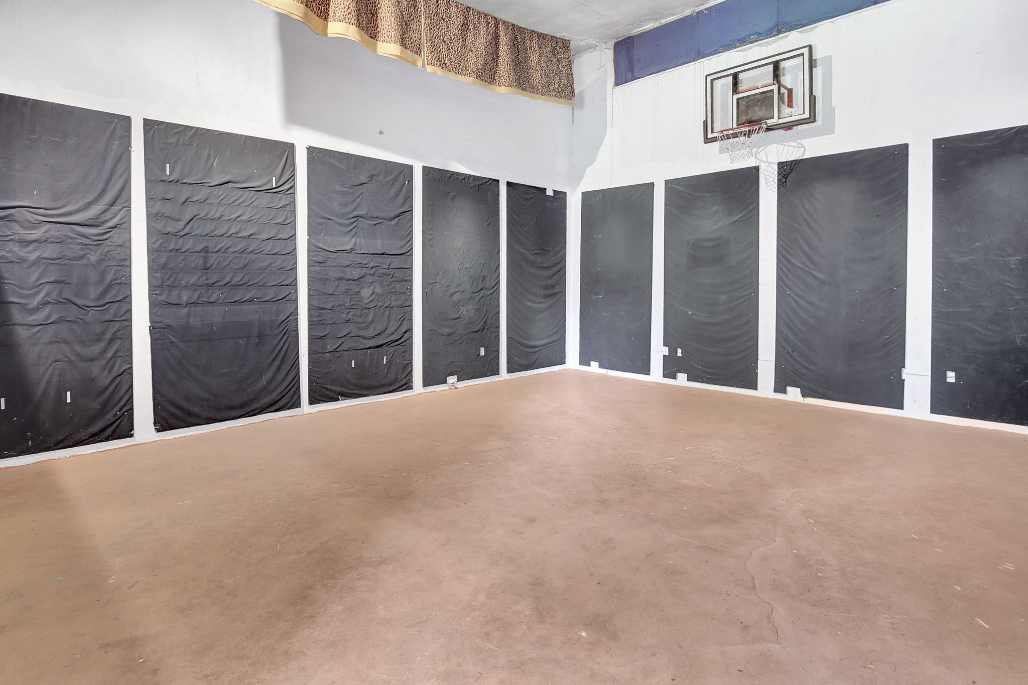 Spacious indoor recreational area featuring a basketball hoop and a large open floor. 24X20 under garage. with separate access