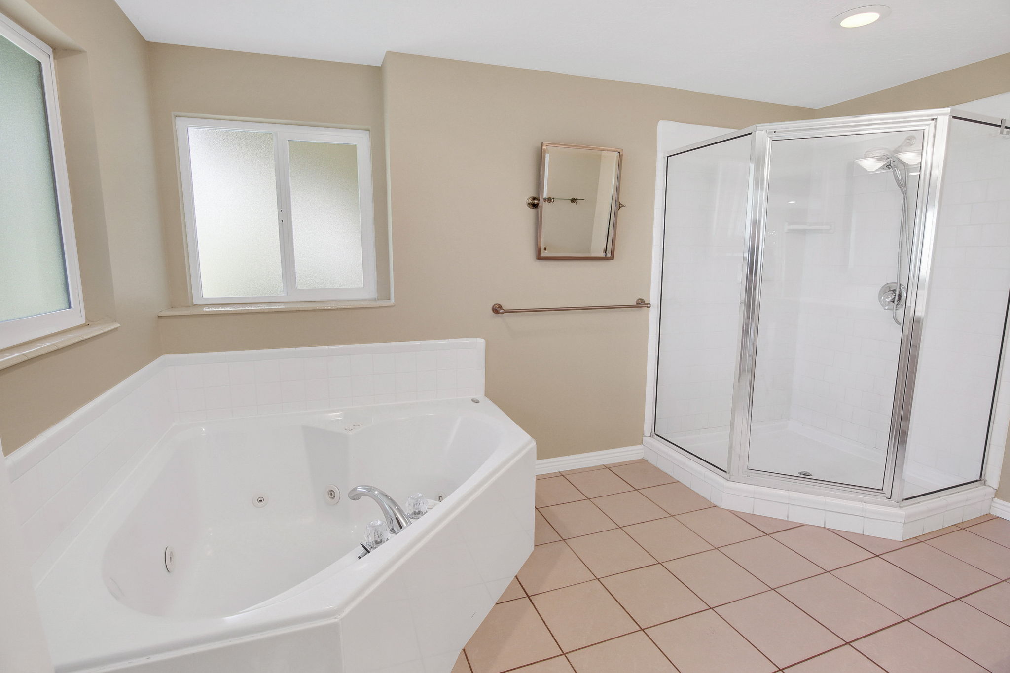 Lower level ensuite in 2nd Primary suite. Corner jetted tub with separate shower. polished chrome fixtures and frosted window