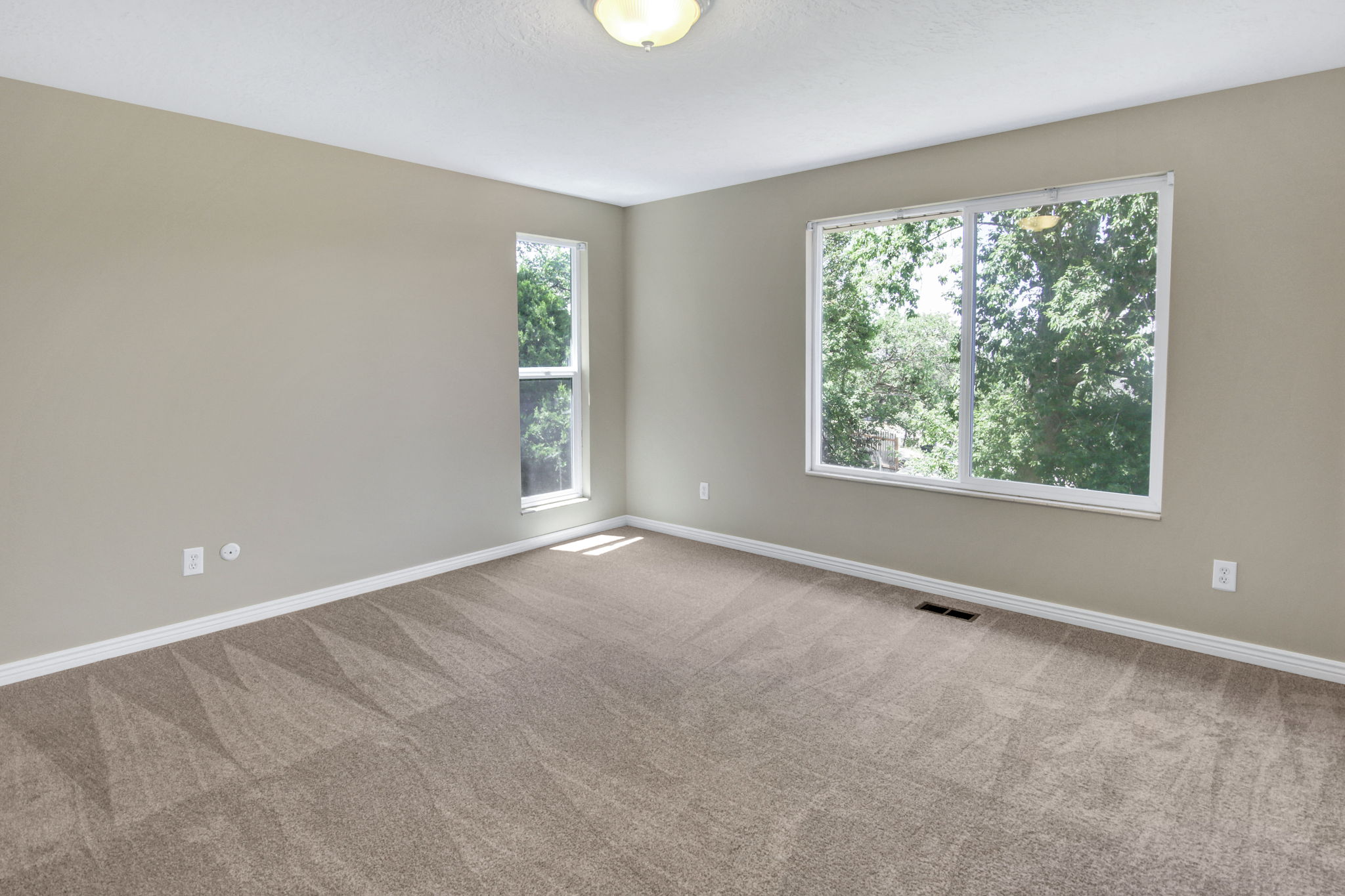 Main floor primary bedroom Spacious room featuring lovely exterior views