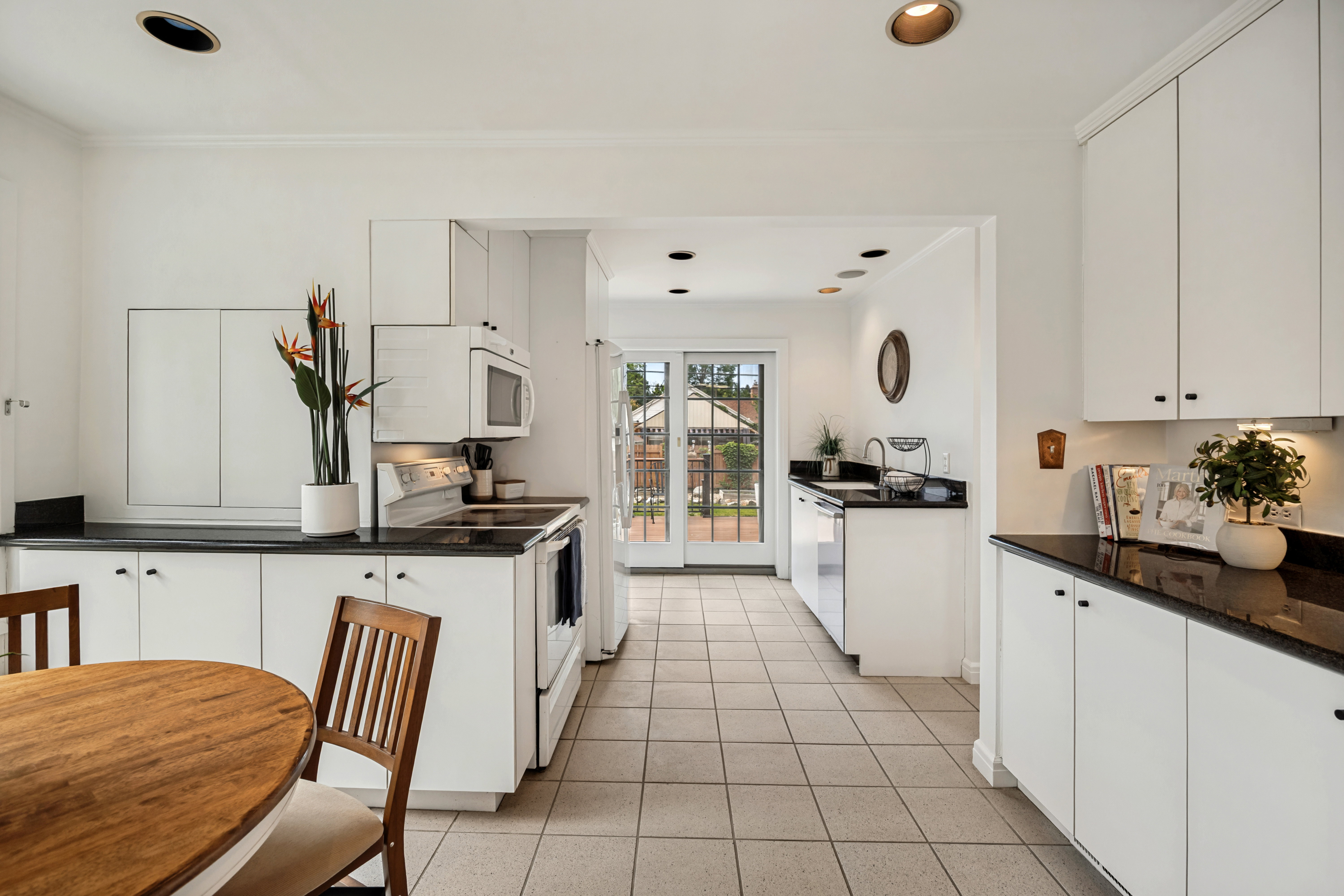 Kitchen featuring white cabinetry, dark countertops, a white electric range, and a built-in microwave