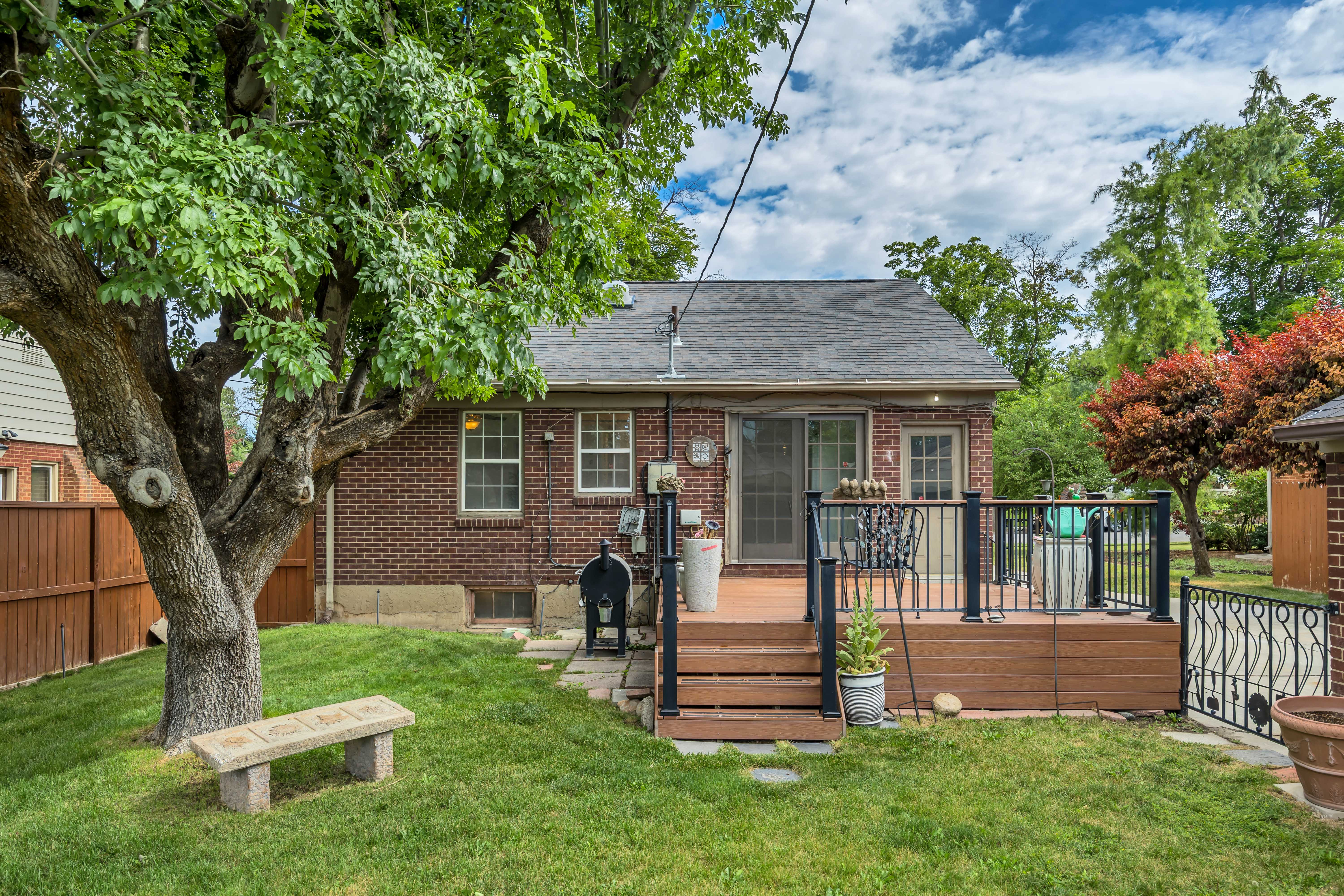 Brick exterior featuring a wood-look composite deck with black railings and steps