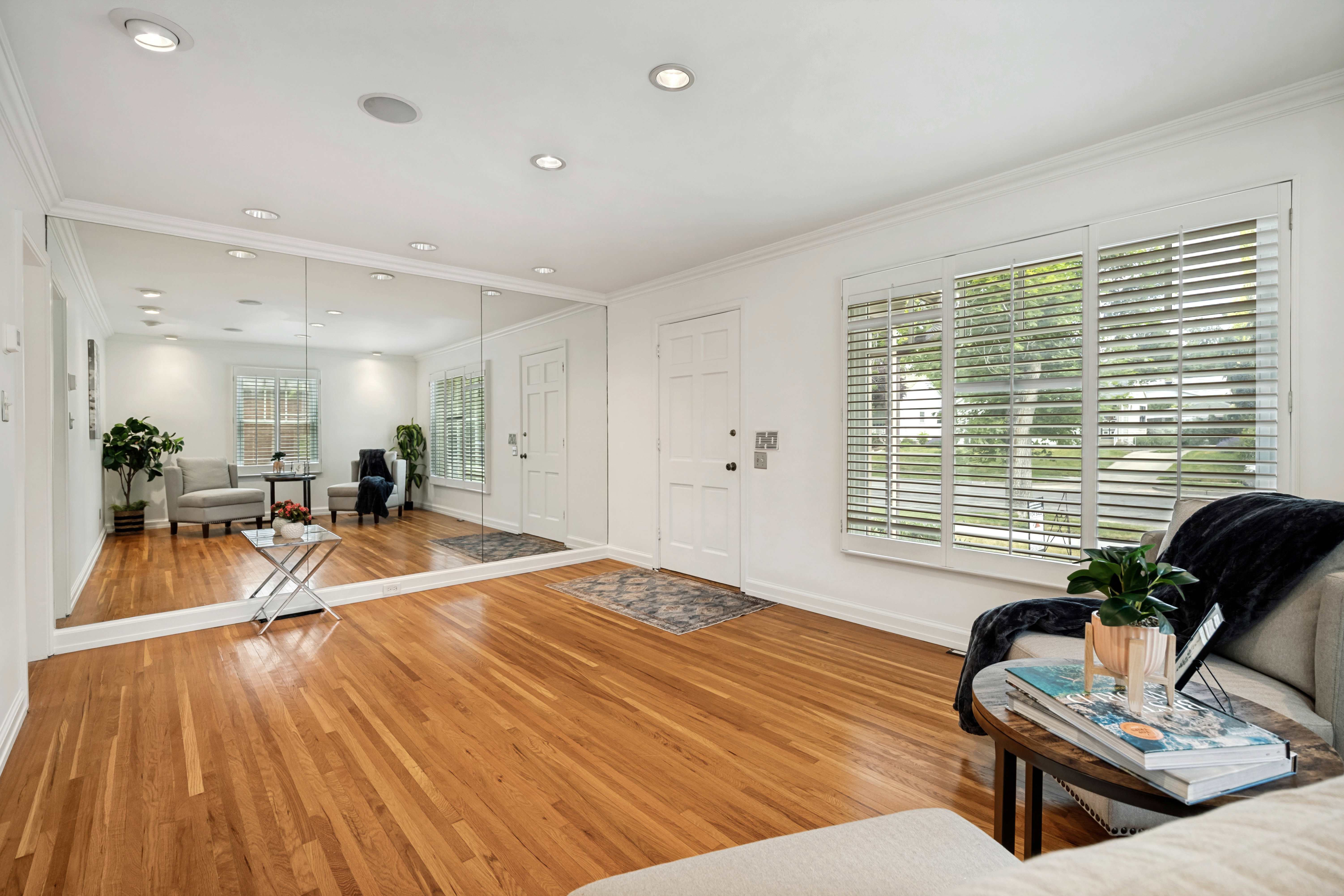 Hardwood flooring throughout complemented by a wall of full-length mirrors