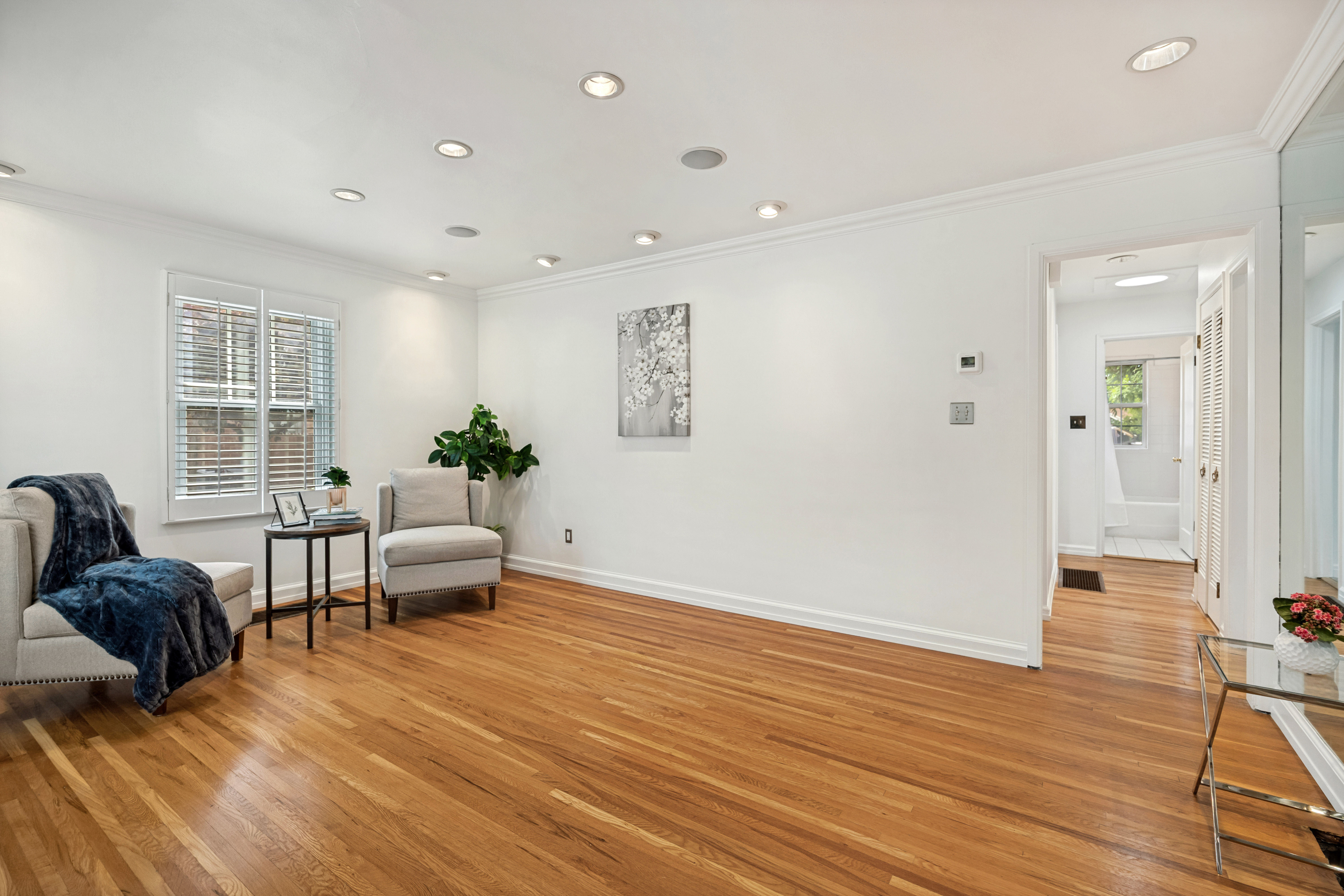 Hardwood flooring extending throughout, complemented by white walls and crown molding