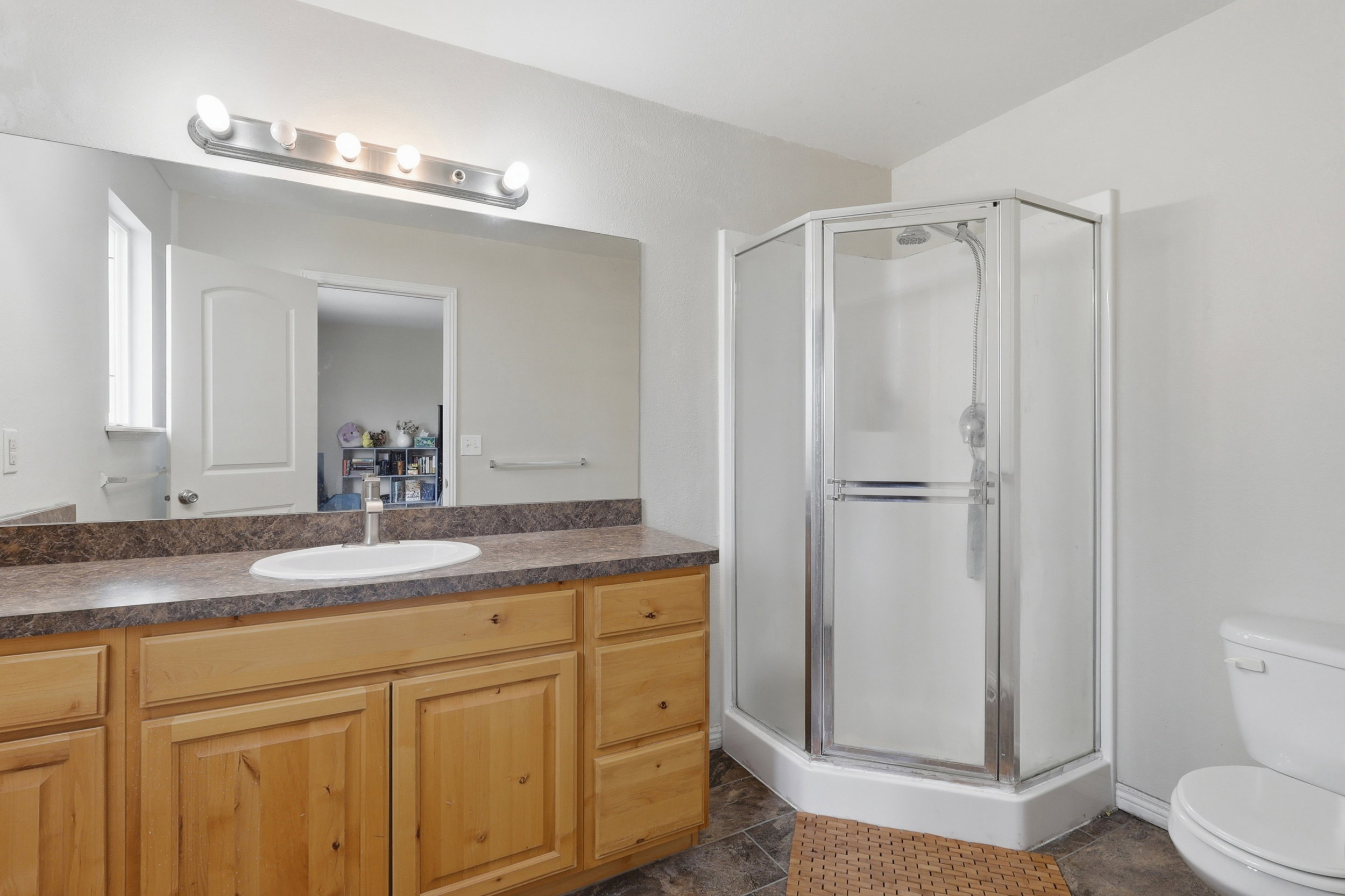 Built-in vanity featuring wood cabinetry, an integrated sink, and a laminate countertop