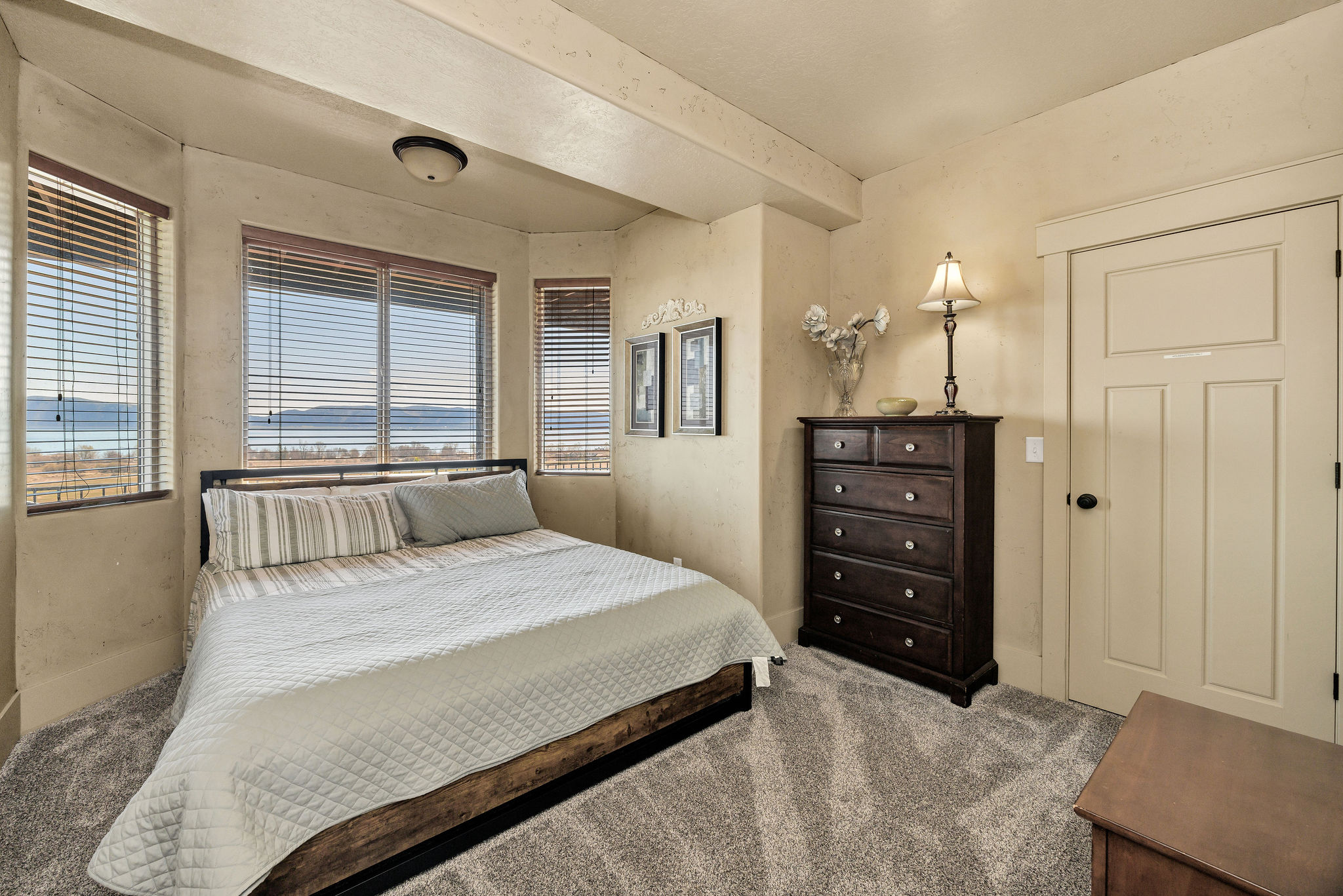 Neutral tone walls complement the textured carpet flooring
