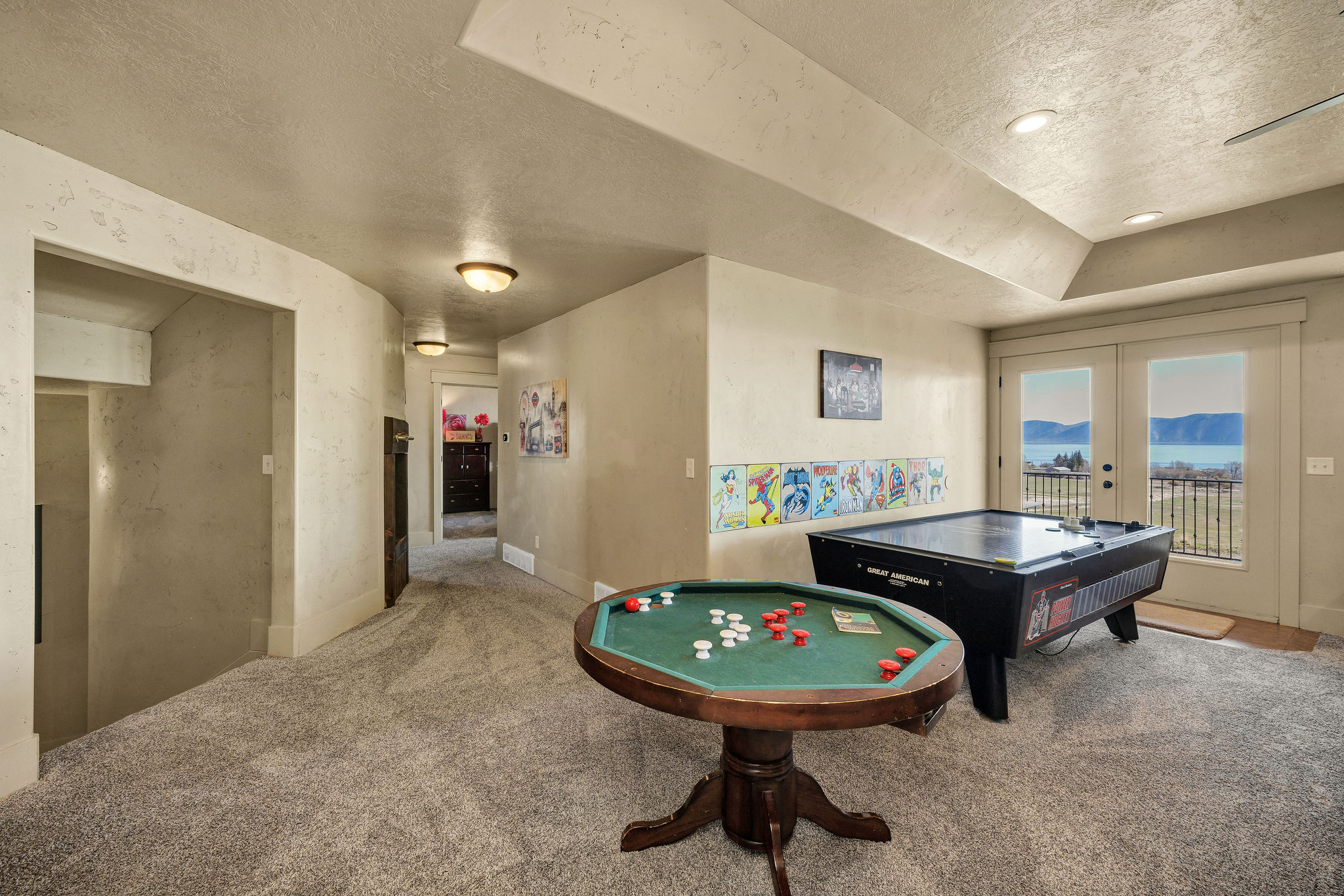 Recreational room featuring plush grey carpet, recessed lighting, and french doors opening to a wrought iron balcony