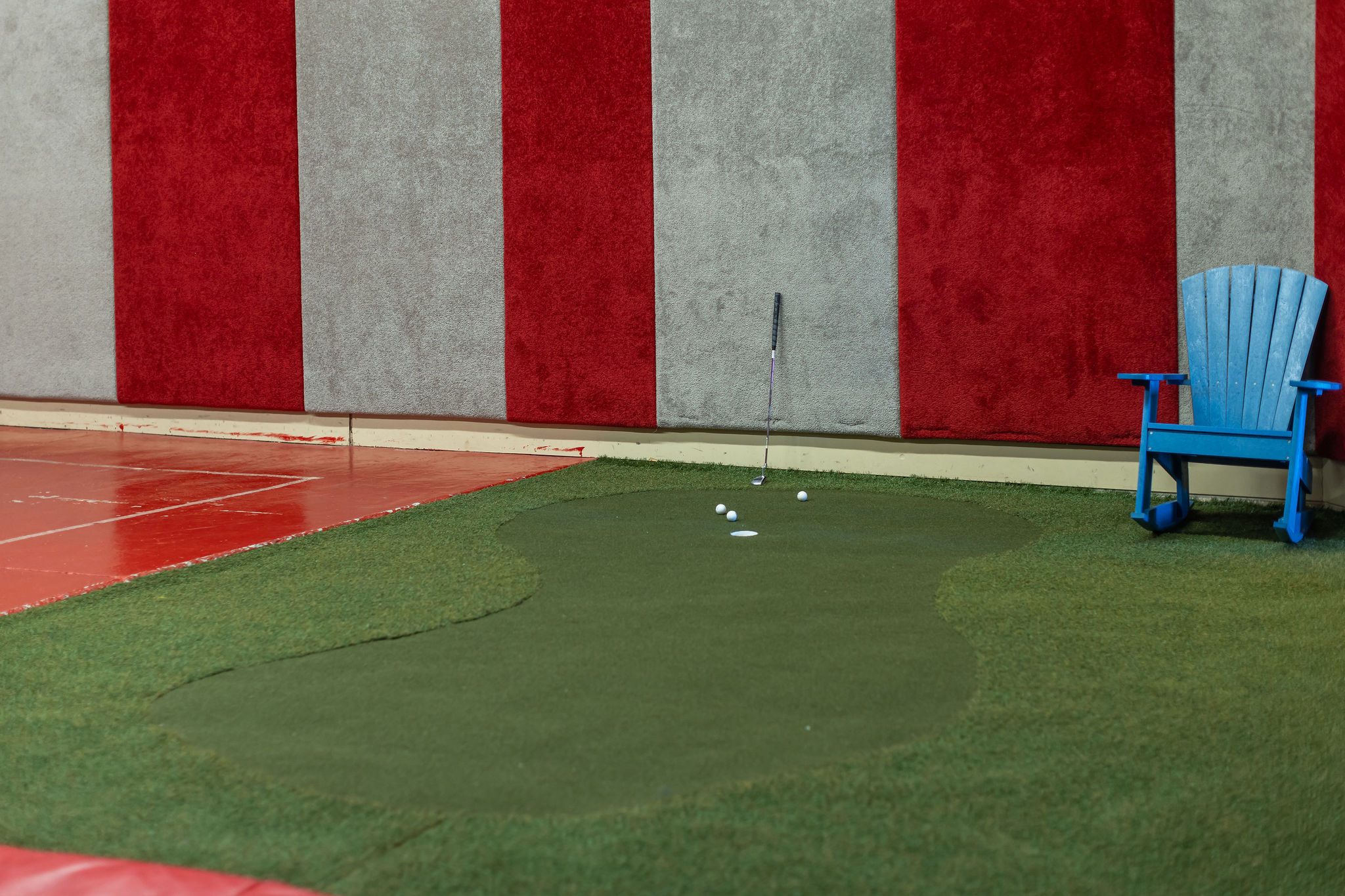 Indoor putting green with surrounding artificial turf