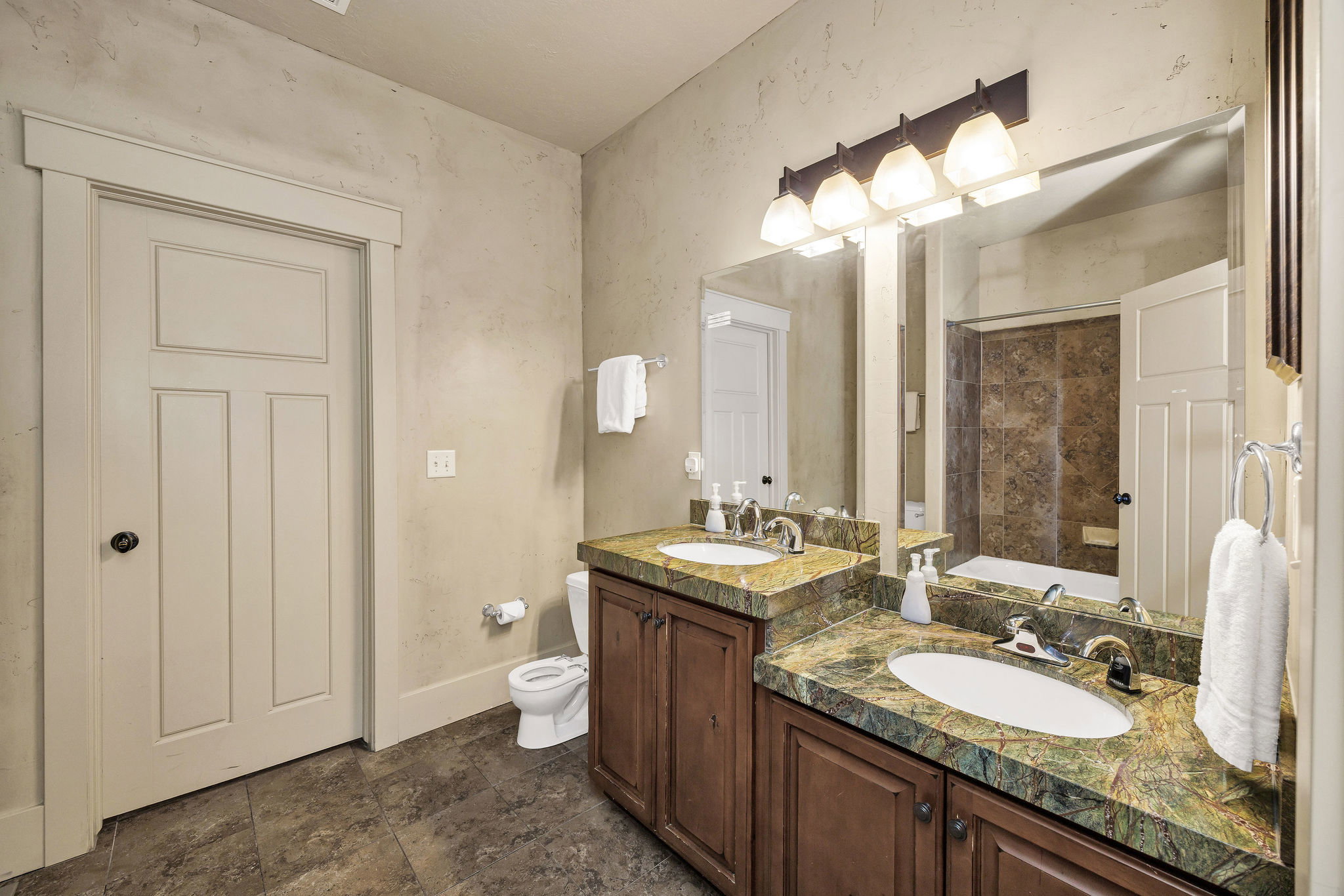 Dual undermount sinks with chrome fixtures set into a green-patterned countertop