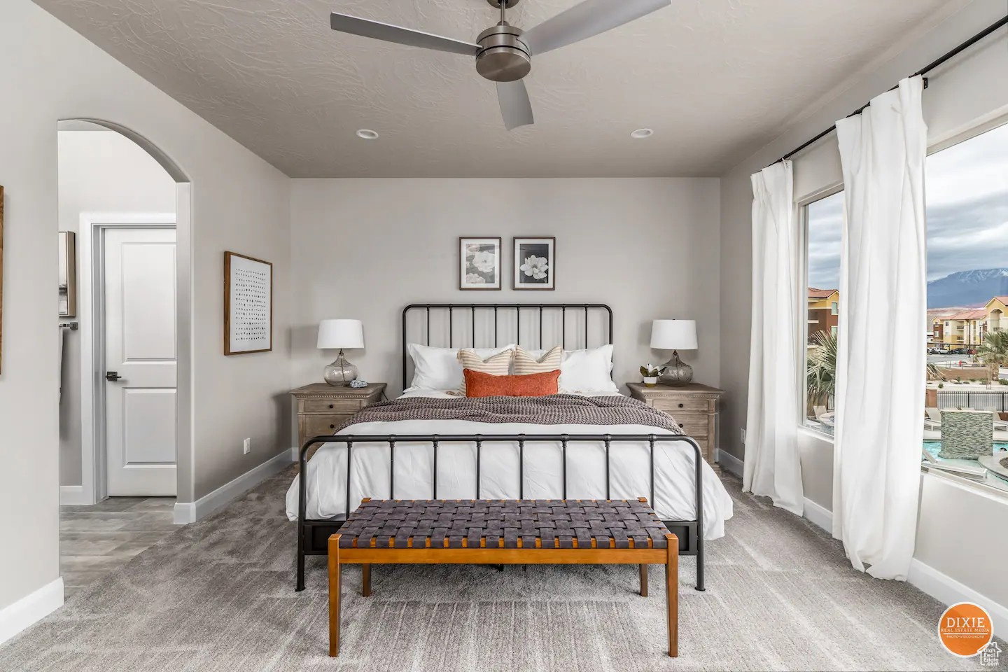 Spacious room featuring broad windows with mountain scenery, a ceiling fan, recessed lighting, an arched doorway, and patterned carpeting