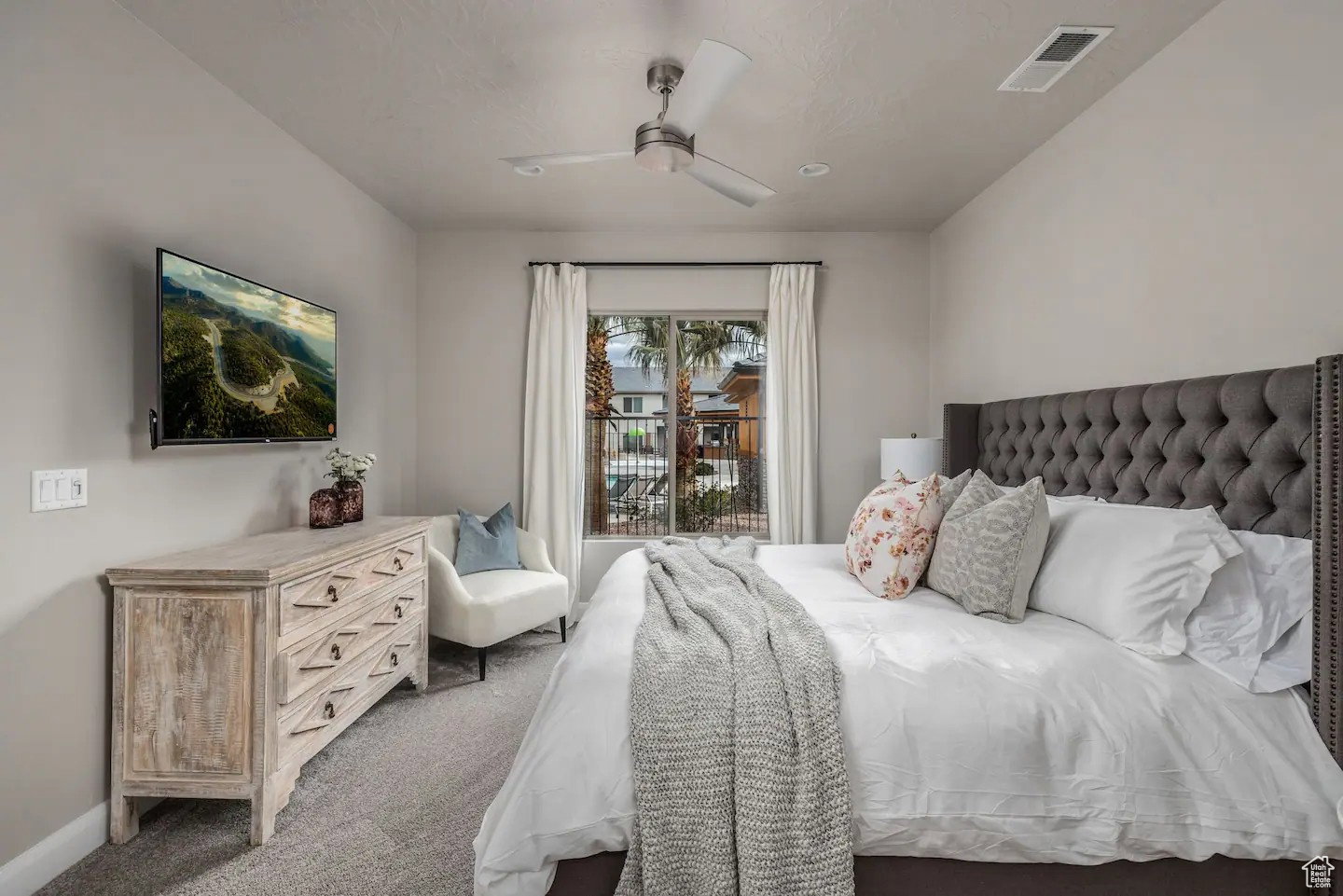 Carpeted room featuring a tufted upholstered headboard, recessed lighting, and a ceiling fan