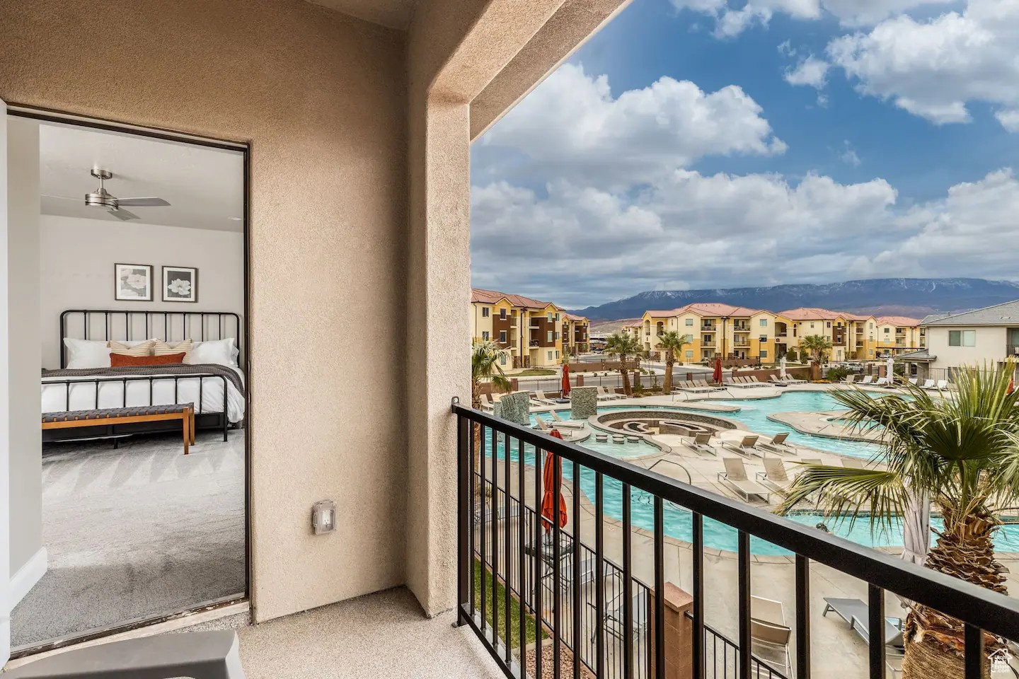 Private balcony featuring a black metal railing and stucco exterior