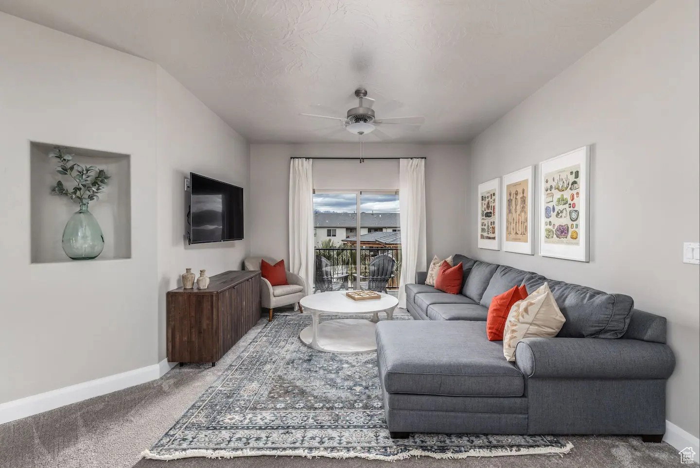 Living area featuring a built-in wall niche, ceiling fan, and access to an outdoor balcony