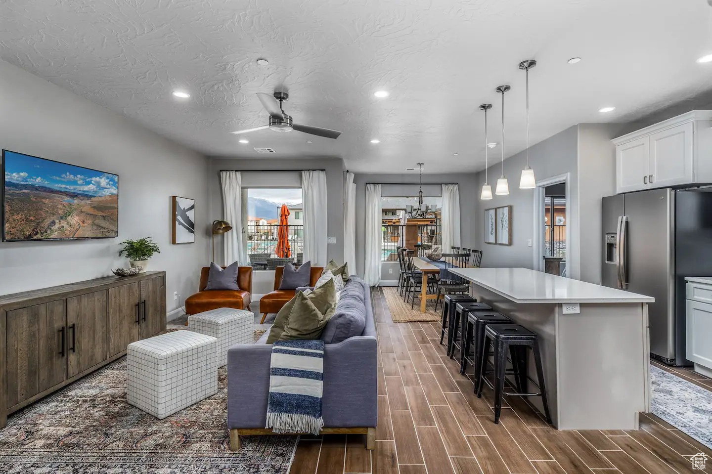 Open-concept living area with wood-finish flooring, recessed lighting, and a ceiling fan
