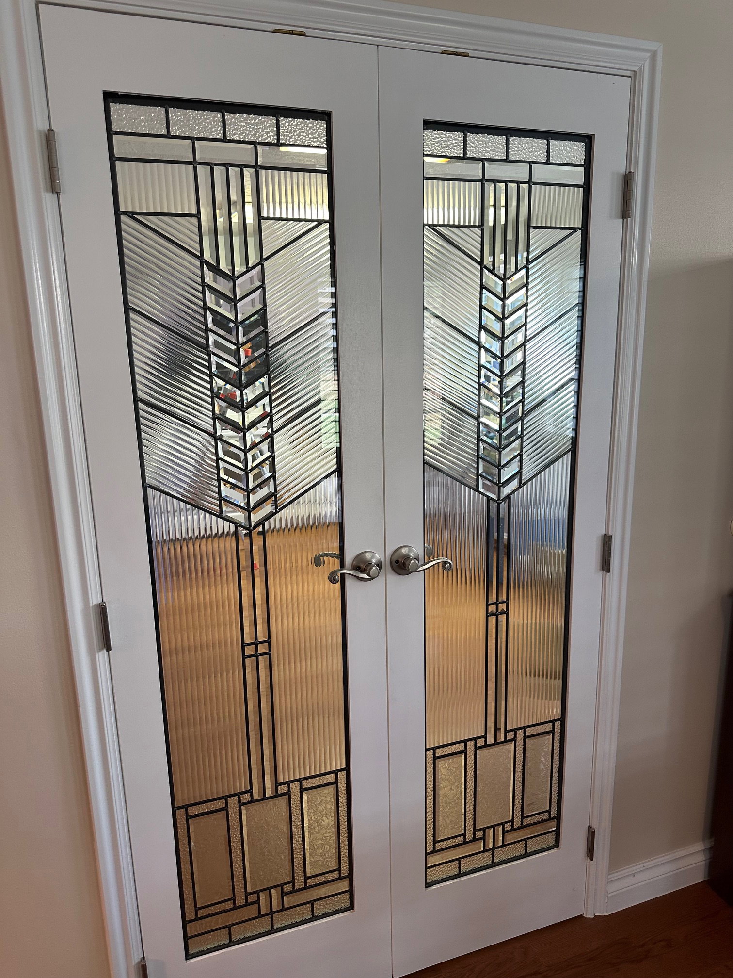 White French doors with decorative glass separate the main room from the kitchen.