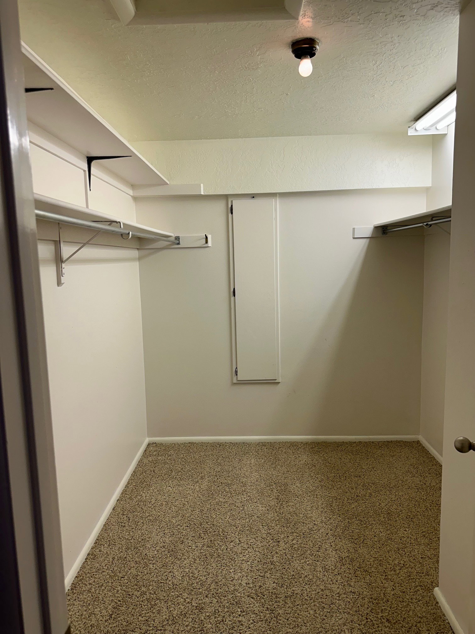 Spacious walk-in closet featuring a built- in ironing board
